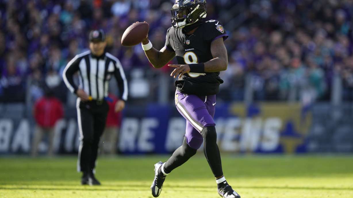 Baltimore Ravens quarterback Lamar Jackson (8) looks to pass as he scrambles against the Miami Dolphins during the first half of an NFL football game in Baltimore, Sunday, Dec. 31, 2023.