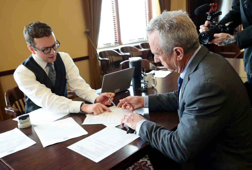 Brody Bailey, elections coordinator for the Office of the Utah Lieutenant Governor, assists independent presidential candidate Robert F. Kennedy Jr. as he files to get his name on the Utah ballot at the Capitol in Salt Lake City, on Wednesday.