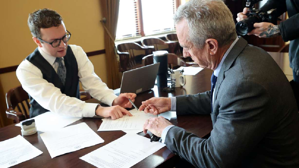 Brody Bailey, elections coordinator for the Office of the Utah Lieutenant Governor, assists independent presidential candidate Robert F. Kennedy Jr. as he files to get his name on the Utah ballot at the Capitol in Salt Lake City, on Wednesday.