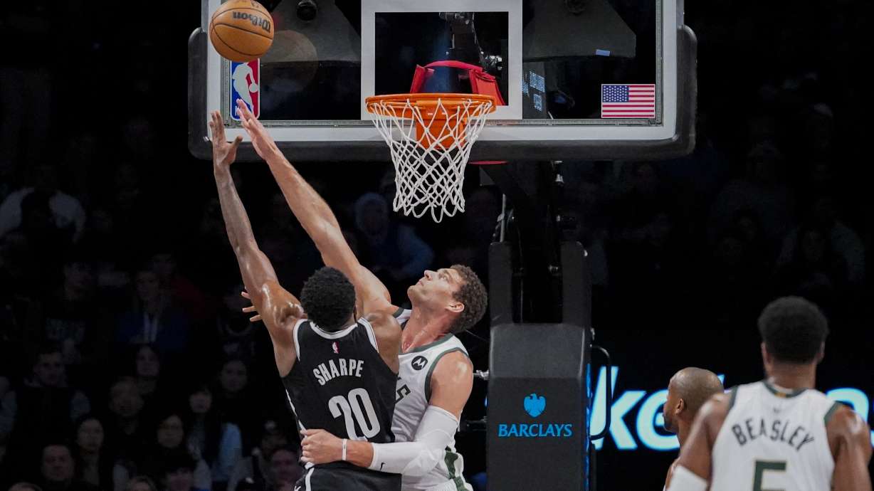 Brooklyn Nets center Day'Ron Sharpe (20) shoots over Milwaukee Bucks center Brook Lopez during the first half of an NBA basketball game Wednesday, Dec. 27, 2023, in New York.