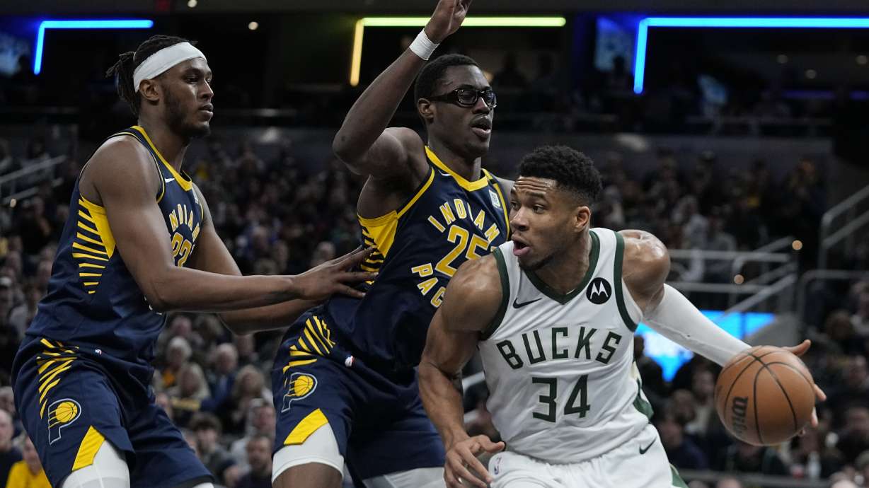 Milwaukee Bucks' Giannis Antetokounmpo (34) goes to the basket against Indiana Pacers' Myles Turner (33) and Jalen Smith (25) during the second half of an NBA basketball game, Wednesday, Jan. 3, 2024, in Indianapolis.