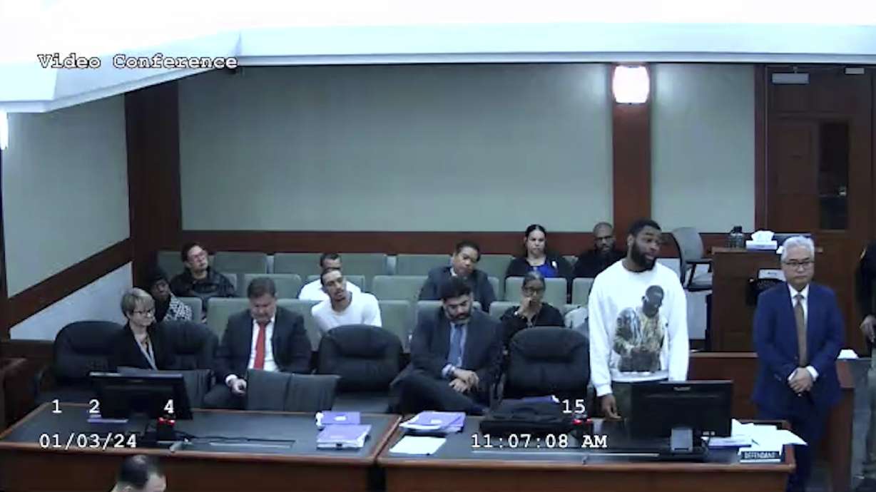 Deobra Redden in a white long-sleeved shirt is seen at his sentencing in a felony battery case, Wednesday, in Las Vegas. The image shows the defendant before a fight with courtroom officers and staff, according to the video and court officials.