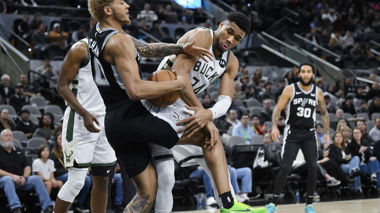 Milwaukee Bucks' Giannis Antetokounmpo (34) becomes entangled with San Antonio Spurs' Jeremy Sochan during the first half of an NBA basketball game Thursday, Jan. 4, 2024, in San Antonio.
