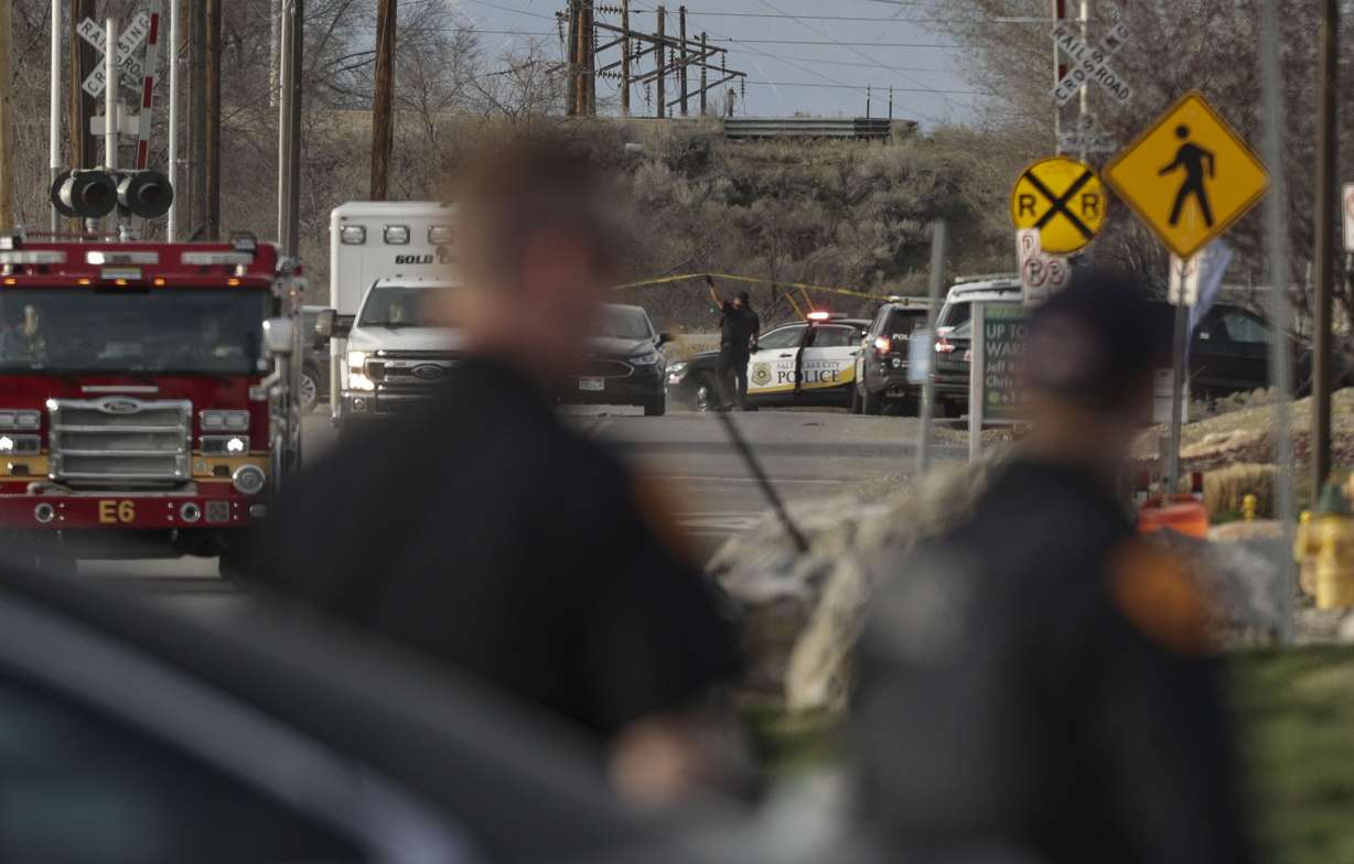 Salt Lake City police work at the scene after shots were fired following a carjacking on Orange Street near 200 South in Salt Lake City on March 26, 2022.