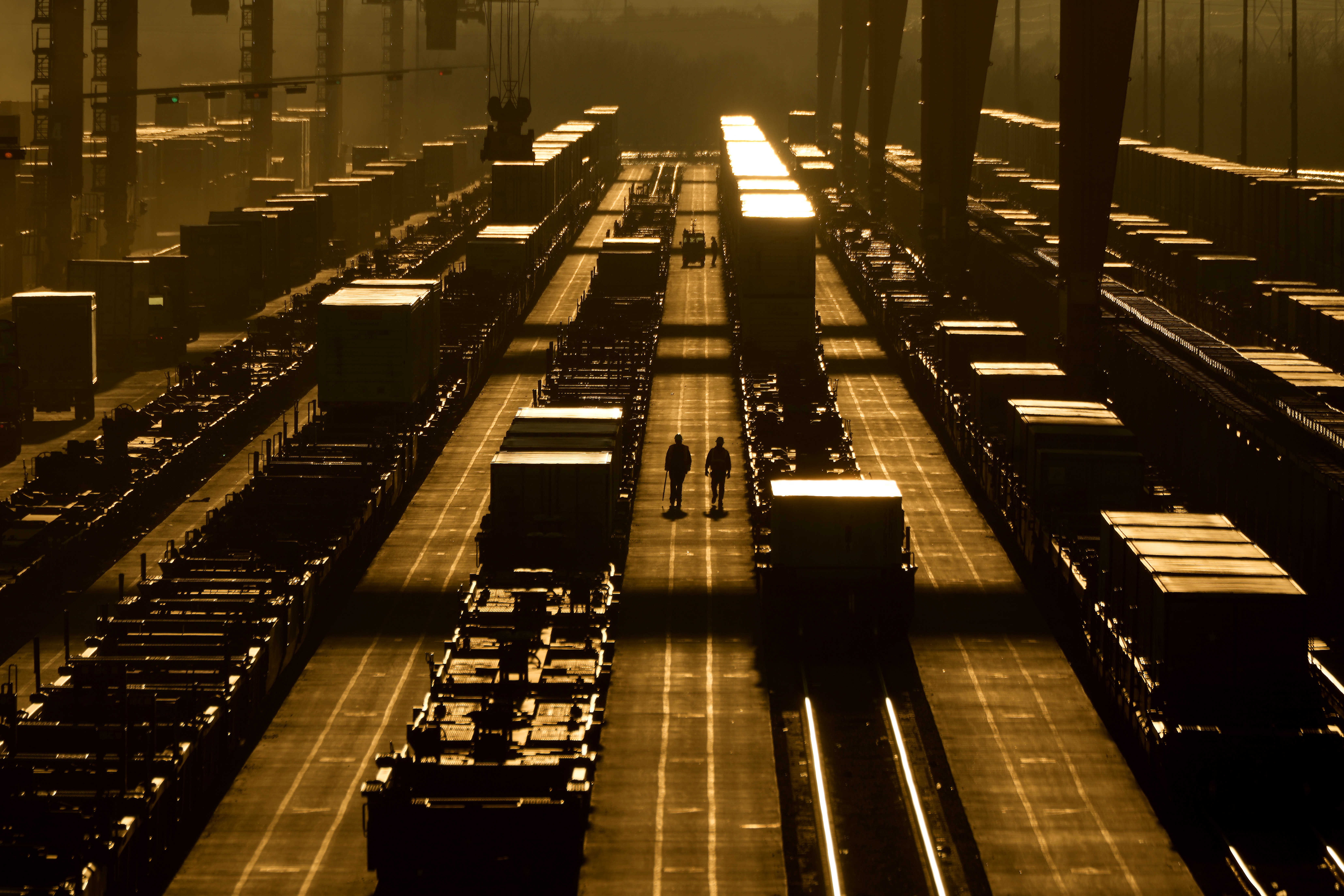 Workers walk among shipping containers at a BNSF intermodal terminal, Wednesday in Edgerton, Kansas. On Friday, the U.S. government issued its December jobs report.