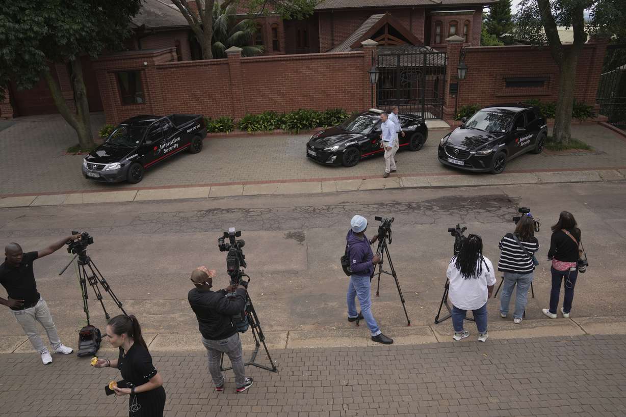 Press gather outside the home of Oscar Pistorius' uncle in the upmarket suburb of Waterkloof, Pretoria, South Africa, Friday. South African athlete Pistorius has been released from prison on parole after serving nearly nine years in prison for killing his girlfriend Reeva Steenkamp on Valentine's Day in 2013 .