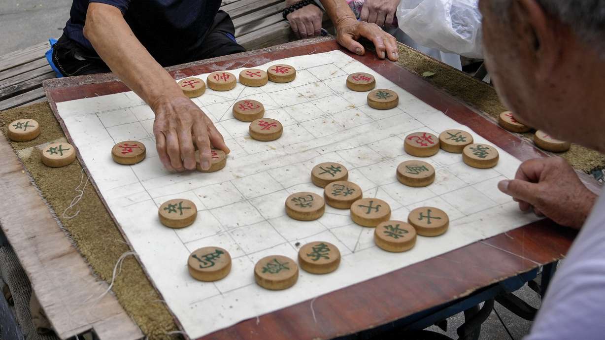 FILE - Residents play Chinese chess games outside a residential area in Beijing on July 19, 2021. A competitor in Chinese chess says he has sued the national association in China for mental distress after he was stripped of a title for drinking alcohol and defecating in the bathtub of his hotel room at a recent competition. Yan Chenglong 's complaint — which demands that the association apologize, restore his reputation in the media and pay him 100,000 yuan ($14,000) in damages — was mailed to a court in central China's Henan province on Monday, Jan. 1, 2024, according to a post on Yan's social media account.