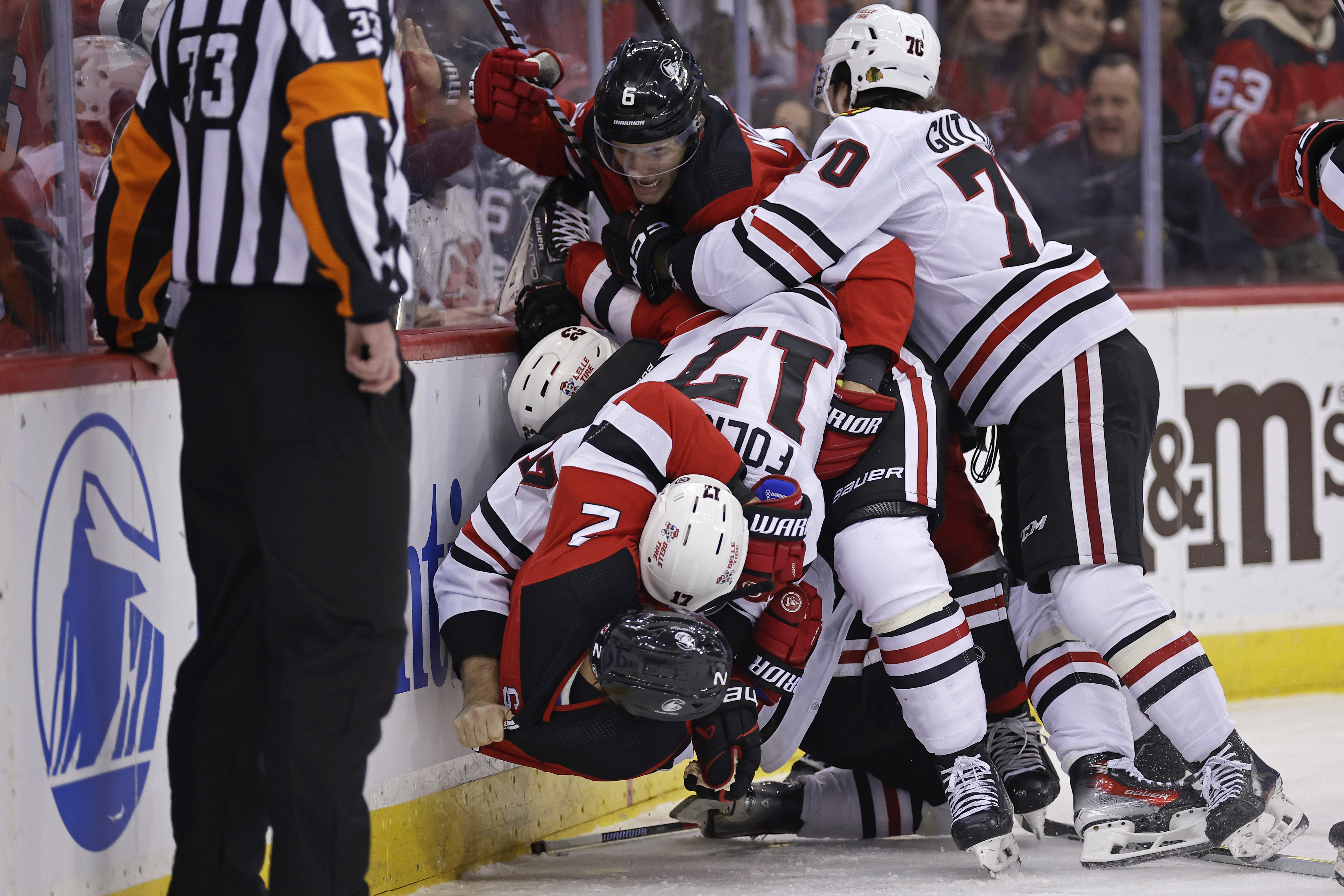 Chicago Blackhawks left wing Nick Foligno (17) throws New Jersey Devils defenseman Brendan Smith (2) to the ice as Blackhawks center Cole Guttman (70) holds back Devils defenseman John Marino (6) during the first period of an NHL hockey game Friday, Jan. 5, 2024, in Newark, N.J.