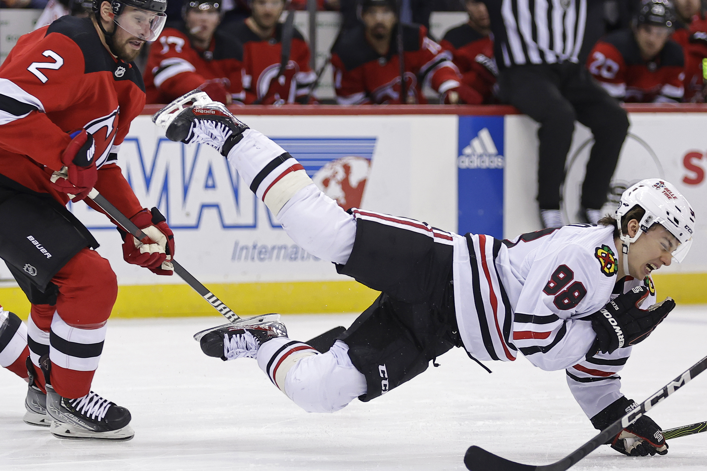 Chicago Blackhawks center Connor Bedard falls to the ice after being checked by New Jersey Devils defenseman Brendan Smith (2) during the first period of an NHL hockey game Friday, Jan. 5, 2024, in Newark, N.J. 