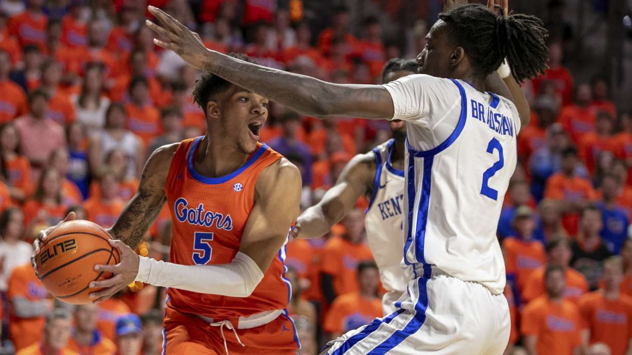 Florida guard Will Richard (5) passes around Kentucky Wildcats forward Aaron Bradshaw (2) during the first half of an NCAA college basketball game Saturday, Jan. 6, 2024, in Gainesville, Fla.