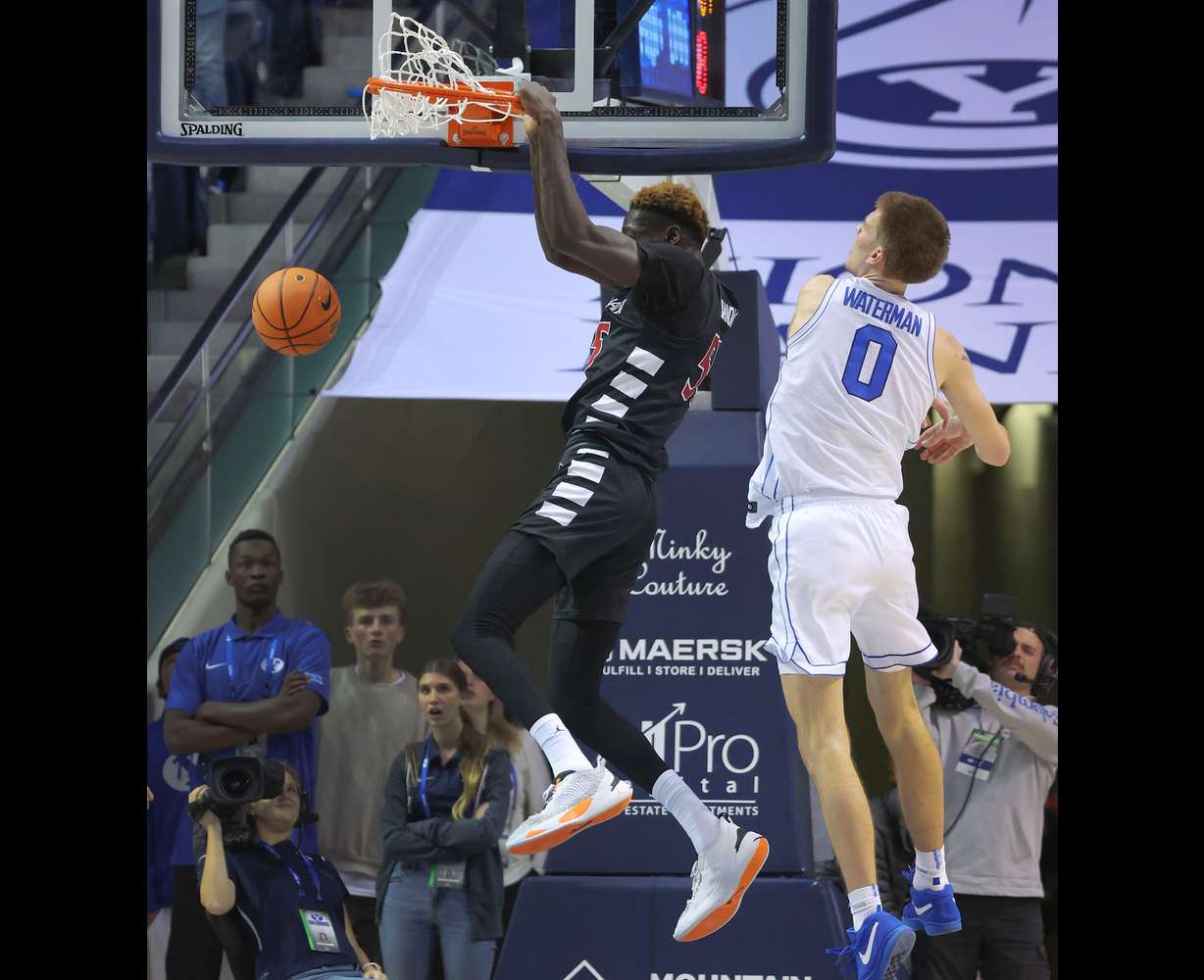 Cincinnati forward Aziz Bandaogo (55) dunks over Brigham Young forward Noah Waterman (0) in Provo on Saturday, Jan. 6, 2024. Cincinnati won 71-60.