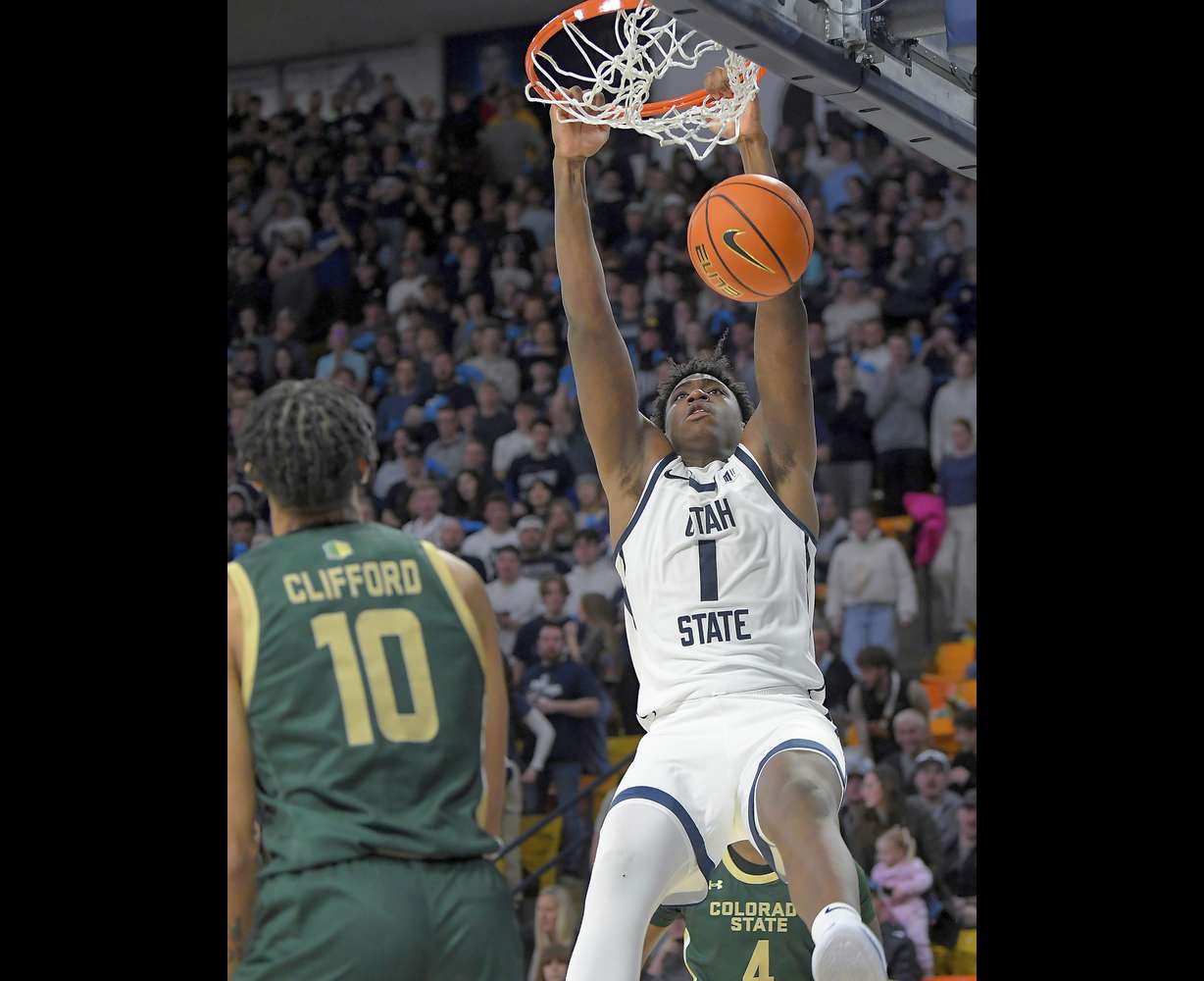 Utah State forward Great Osobor (1) dunks as Colorado State guard Nique Clifford (10) defends during the second half of an NCAA college basketball game Saturday, Jan. 6, 2024, in Logan, Utah.