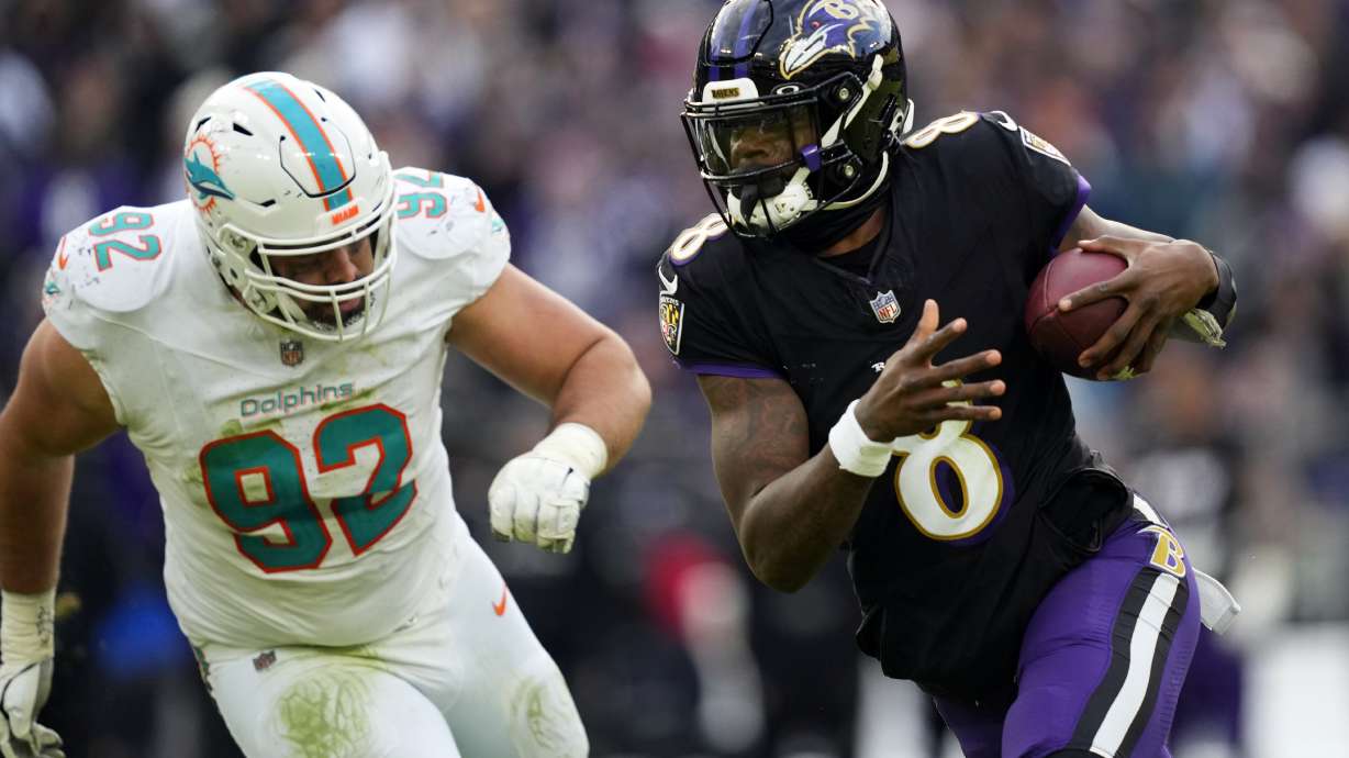 Baltimore Ravens quarterback Lamar Jackson (8) runs against Miami Dolphins defensive tackle Zach Sieler (92) during the second half of an NFL football game in Baltimore, Sunday, Dec. 31, 2023.