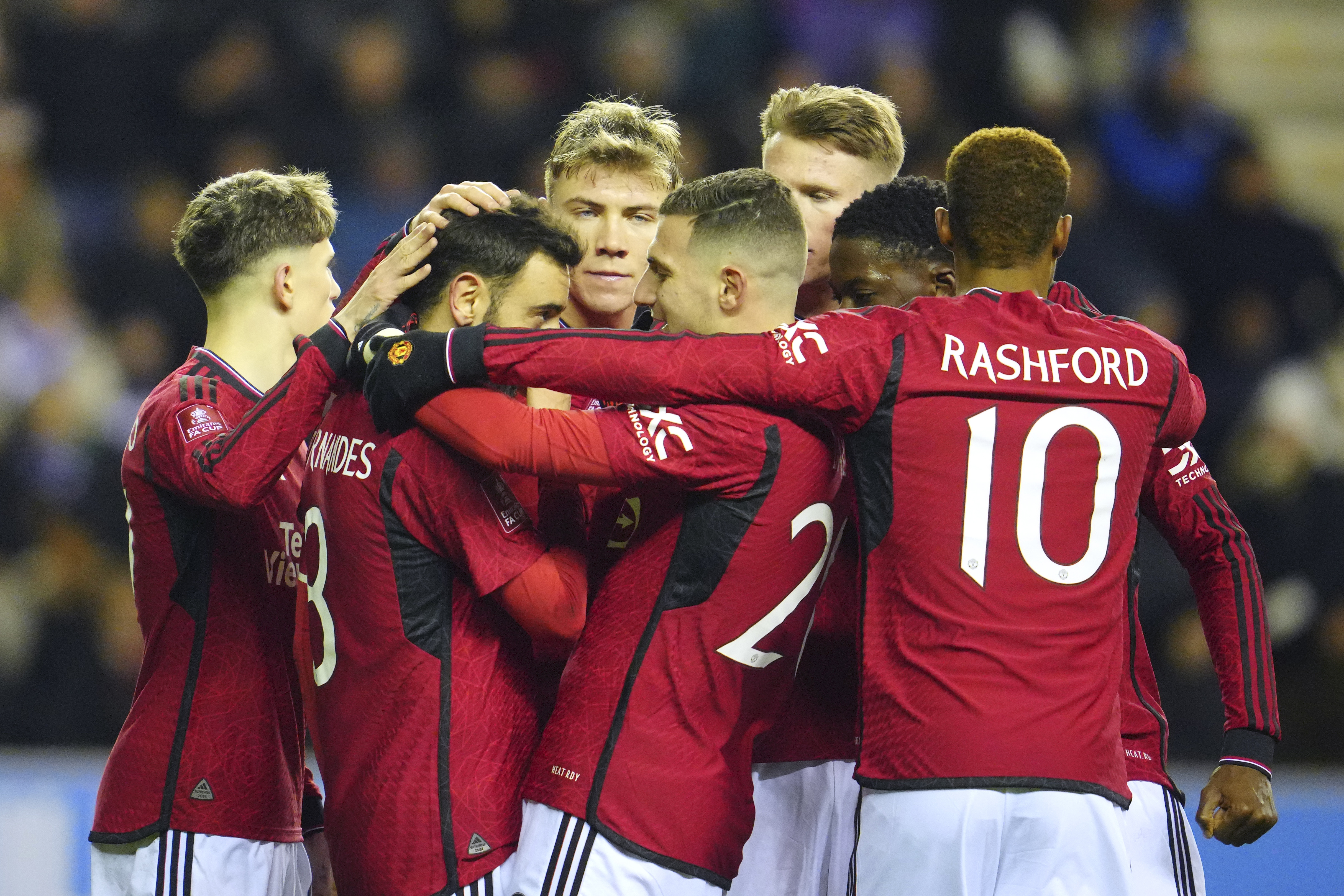 Manchester United players celebrate after Manchester United's Bruno Fernandes scored his side's second goal during the English FA Cup third round soccer match between Wigan Athletic and Manchester United at the DW Stadium, Wigan, England, Monday, Jan. 8, 2024. 