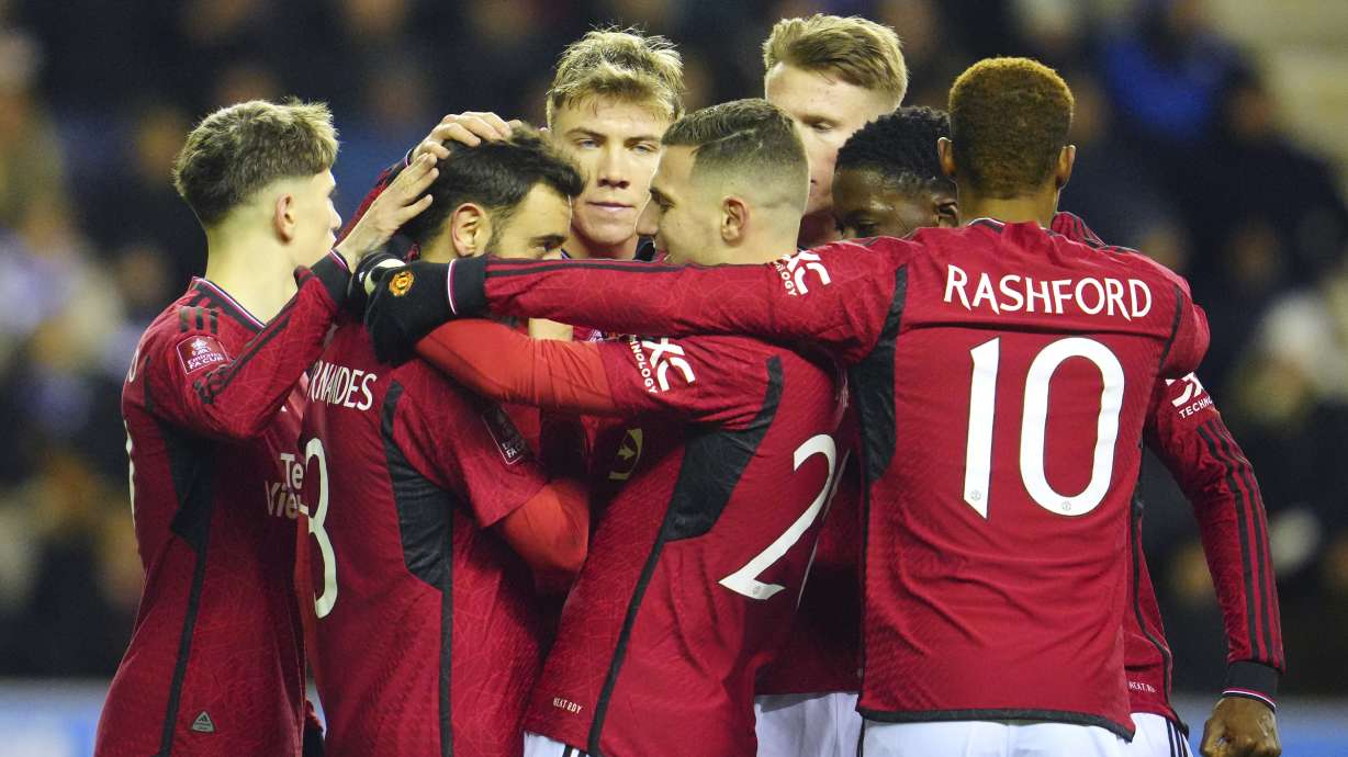 Manchester United players celebrate after Manchester United's Bruno Fernandes scored his side's second goal during the English FA Cup third round soccer match between Wigan Athletic and Manchester United at the DW Stadium, Wigan, England, Monday, Jan. 8, 2024.