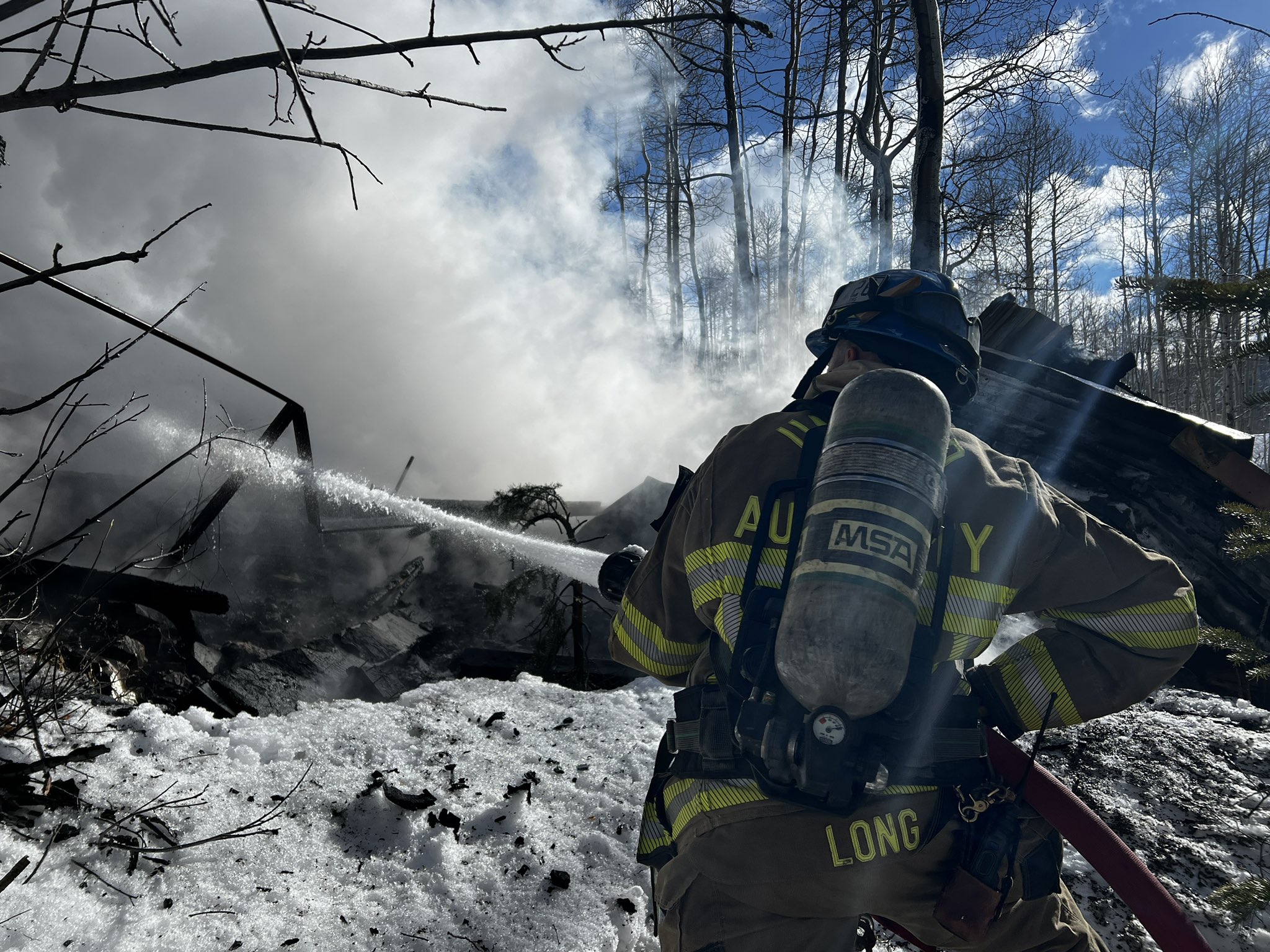 A firefighter works to put out a cabin fire in Big Cottonwood Canyon on Monday. The two-story cabin in Big Cottonwood Canyon was destroyed by a fire Monday, a spokesman for Unified Fire Authority said.