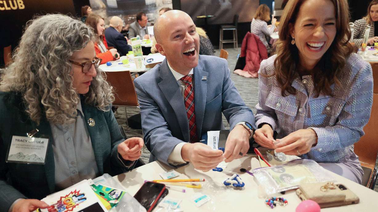 Utah Department of Health and Human Services Executive Director Tracy Gruber, Gov. Spencer Cox and first lady Abby Cox prepare Generus mental health and emotional fluency kits as part of a service project during a Why We Serve symposium at the Delta Center in Salt Lake City on Monday.