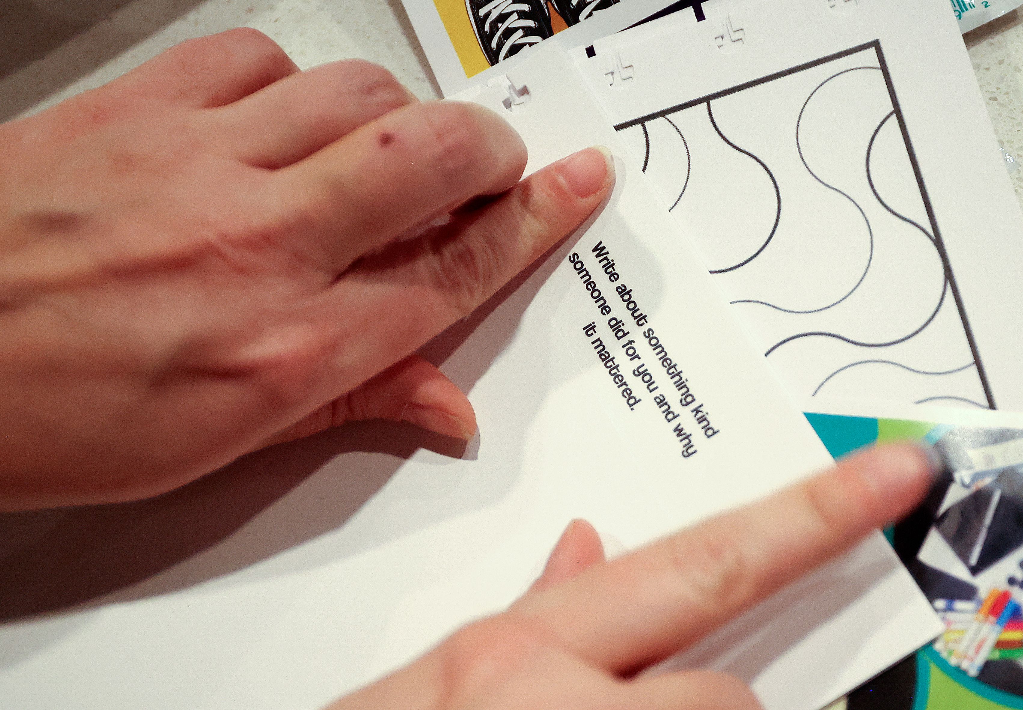 Tess Mason-Elder makes a guided prompt journal while preparing Generus mental health and emotional fluency kits for a service project during a Why We Serve symposium at the Delta Center in Salt Lake City on Monday.