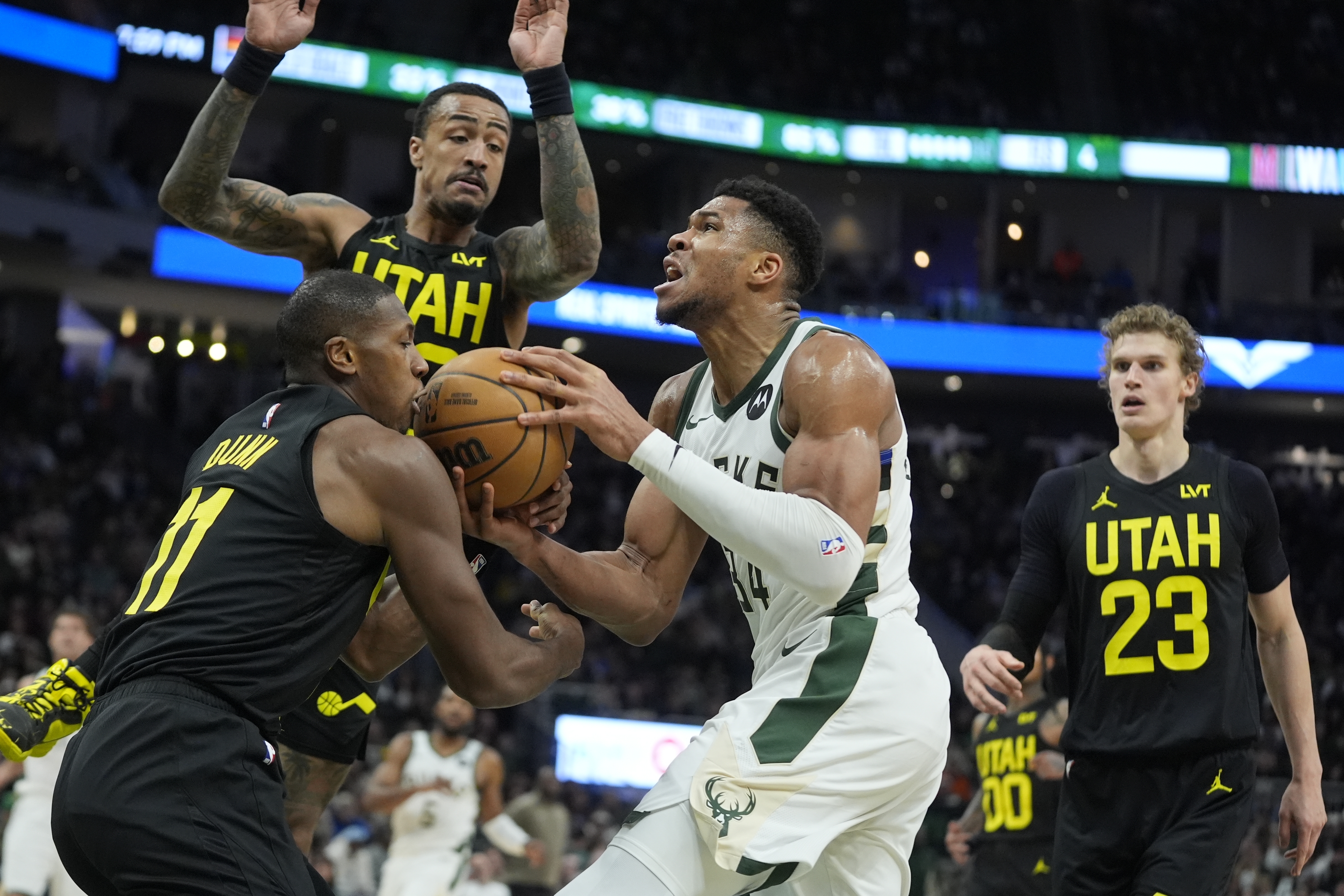 Milwaukee Bucks' Giannis Antetokounmpo tries o drive past Utah Jazz's Kris Dunn during the first half of an NBA basketball game Monday, Jan. 8, 2024, in Milwaukee.