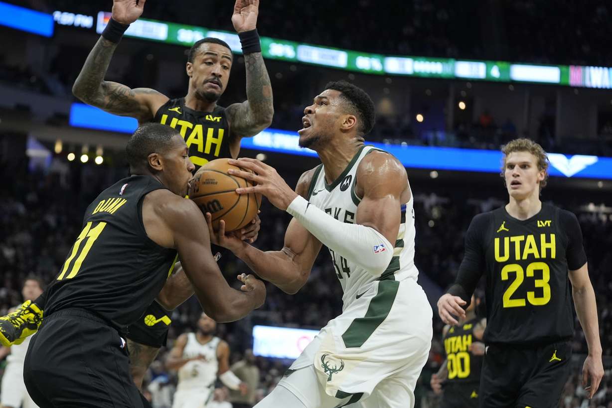 Milwaukee Bucks' Giannis Antetokounmpo tries o drive past Utah Jazz's Kris Dunn during the first half of an NBA basketball game Monday, Jan. 8, 2024, in Milwaukee.