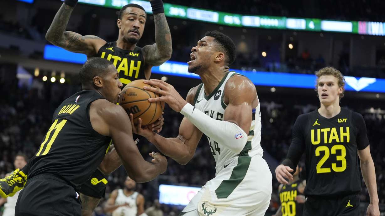Milwaukee Bucks' Giannis Antetokounmpo tries o drive past Utah Jazz's Kris Dunn during the first half of an NBA basketball game Monday, Jan. 8, 2024, in Milwaukee.