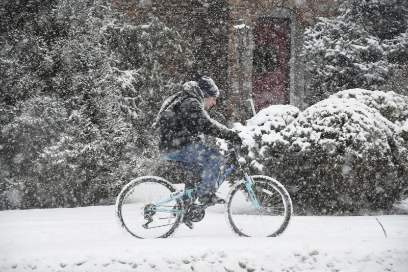 A cyclist navigates the sidewalk along State Road in North Adams, Mass., on Sunday afternoon, during the height of the snowstorm.