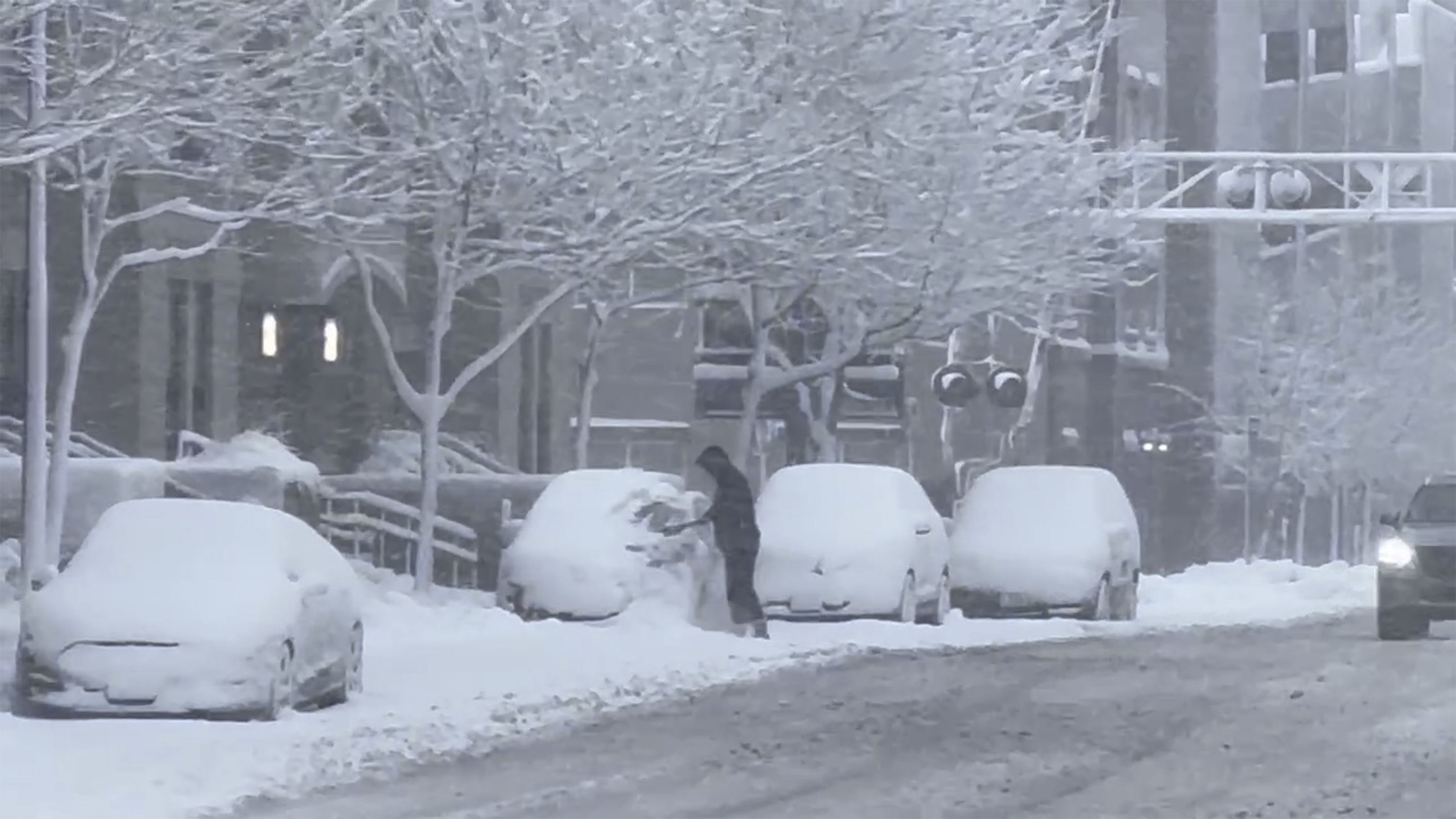 A person clears snow from their car during a snowstorm in Des Moines Iowa on Tuesday. In the Midwest, where a snowstorm started Monday, up to 12 inches of snow could blanket a broad area stretching from southeastern Colorado all the way to the Upper Peninsula of Michigan.
