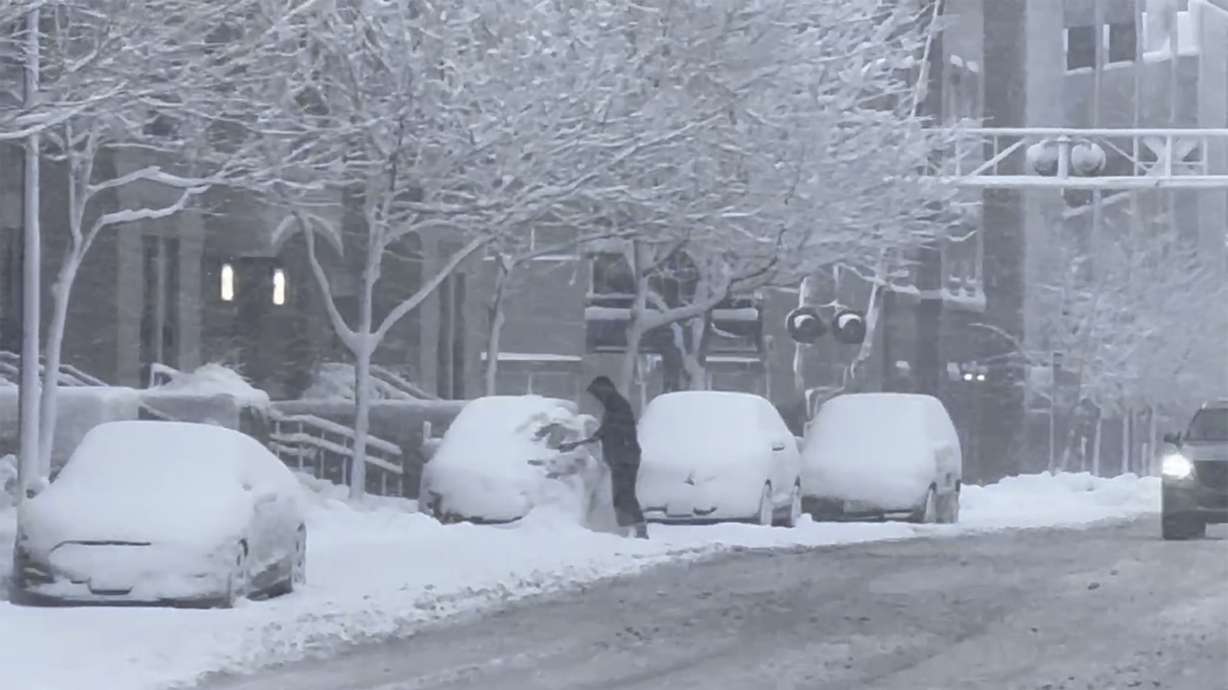 A person clears snow from their car during a snowstorm in Des Moines Iowa on Tuesday. In the Midwest, where a snowstorm started Monday, up to 12 inches of snow could blanket a broad area stretching from southeastern Colorado all the way to the Upper Peninsula of Michigan.