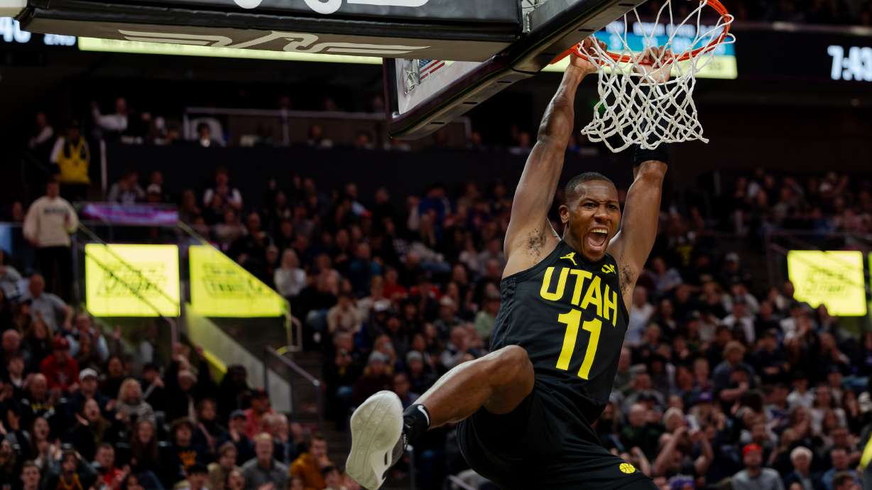 Utah Jazz guard Kris Dunn (11) dunks the ball with an assist from Utah Jazz guard Jordan Clarkson (00) during the NBA basketball game between the Utah Jazz and the Dallas Mavericks at the Delta Center in Salt Lake City on Monday, Jan. 1, 2024.