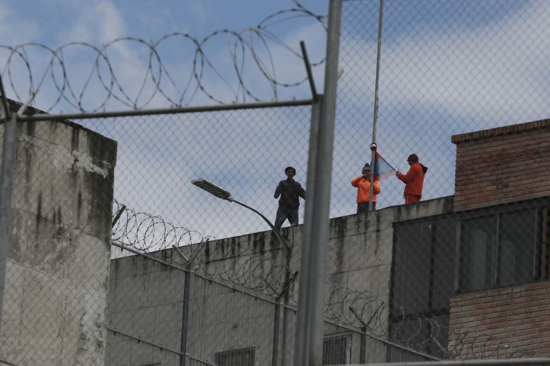 Inmates stand on the top of Turi jail during a prisoner riot in Cuenca, Ecuador. On Monday, President Daniel Noboa decreed a national state of emergency for 60 days, allowing the authorities to suspend rights and mobilize the military in places like prisons.