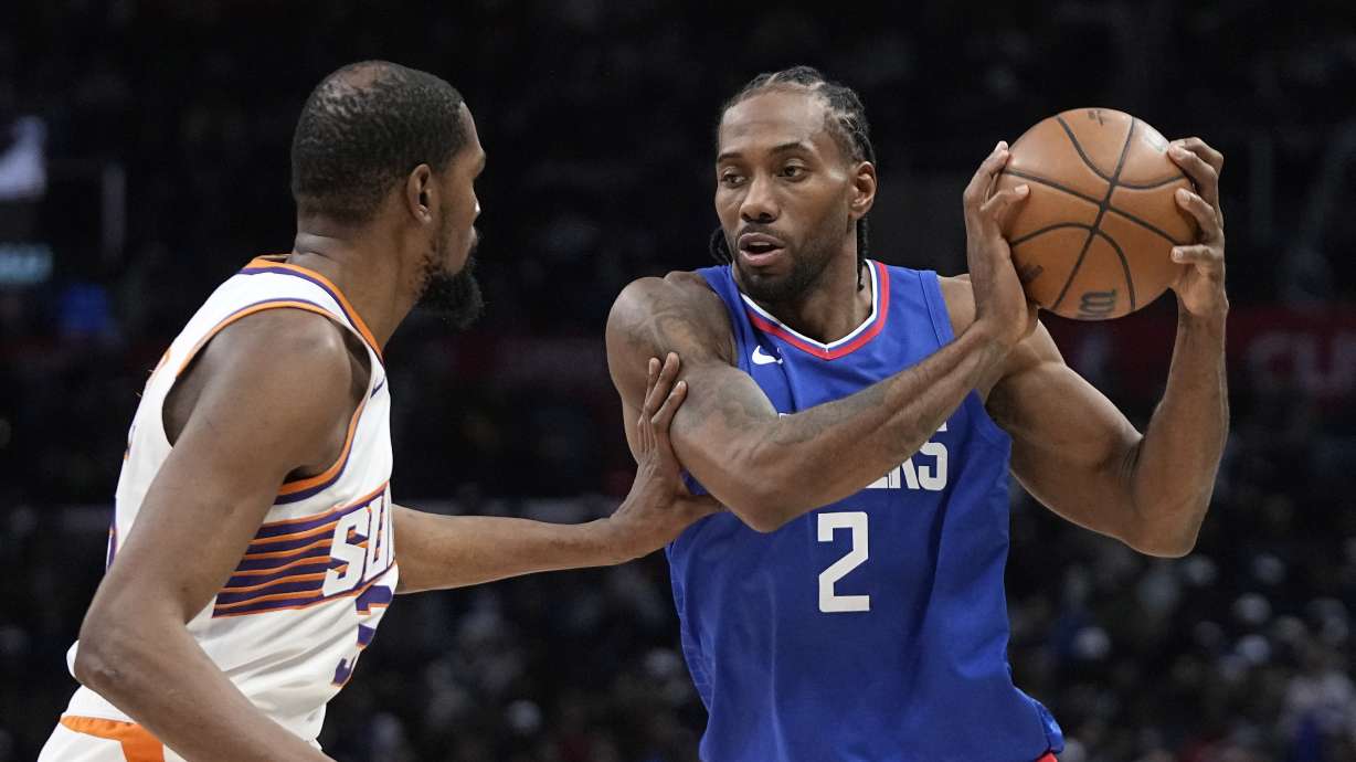 Los Angeles Clippers forward Kawhi Leonard, right, tries to pass as Phoenix Suns forward Kevin Durant defends during the second half of an NBA basketball game Monday, Jan. 8, 2024, in Los Angeles.