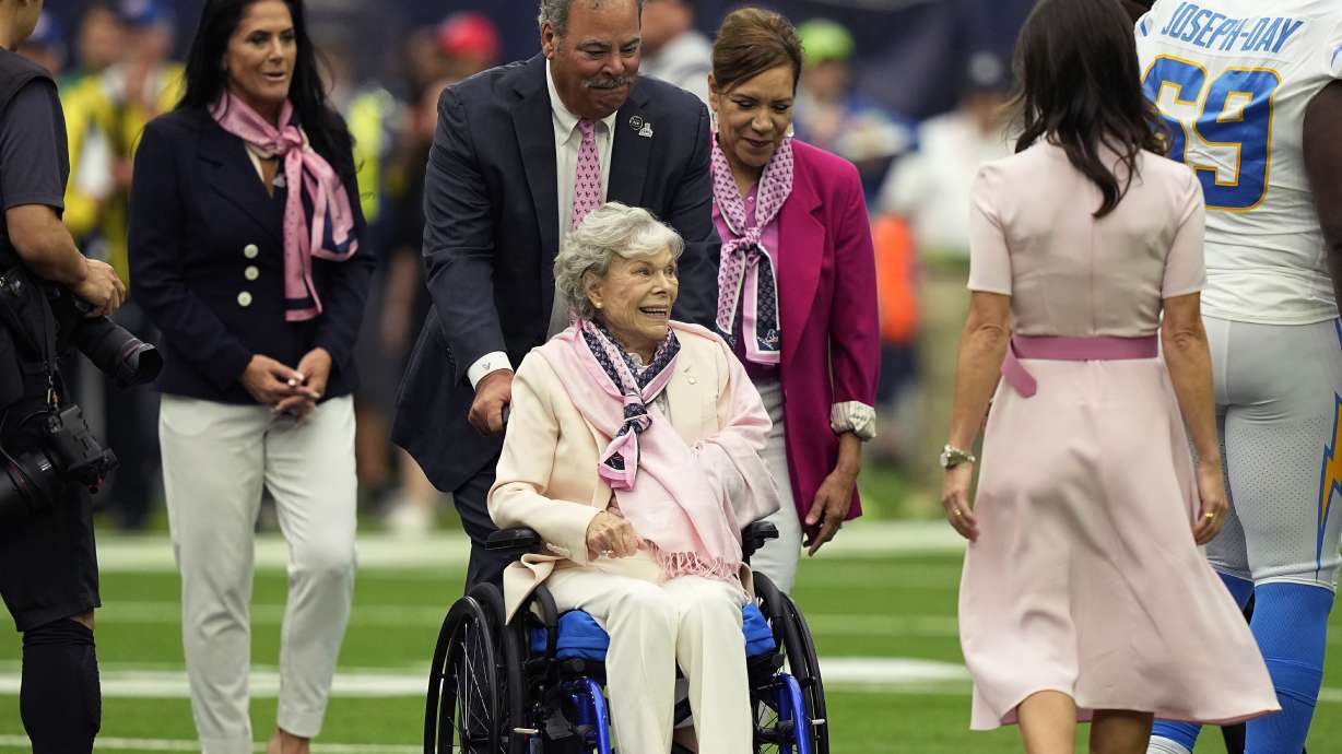 FILE - Houston Texans owner Janice McNair, enters with her son, Chairman and CEO Cal McNair before an NFL football game against the Los Angeles Chargers, Sunday, Oct. 2, 2022, in Houston. Court records show the owner of the Houston Texans is fighting efforts by one of her sons to have her declared incapacitated and have a guardian appointed for her. Janice McNair is fighting the guardianship proceeding initiated by one of her sons, Robert Cary McNair Jr. Attorneys for Janice McNair and her son Cal McNair, say the claims she's incapacitated are “drastic and unwarranted.”