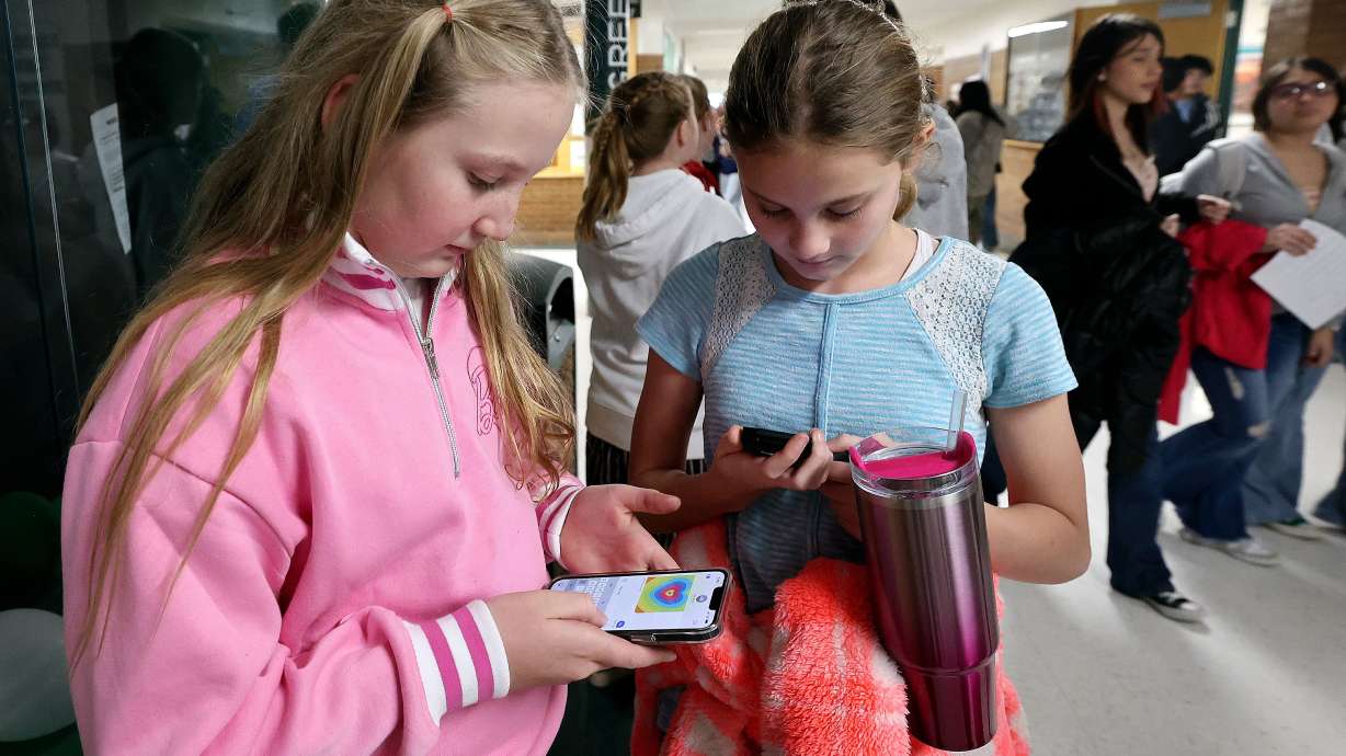 Sixth graders Ashton Wiggins and Aspen Pace use their cellphones after school at Evergreen Junior High School in Millcreek on Wednesday. Utah Gov. Spencer Cox on Wednesday lifted up the Millcreek school as an example where cellphone restrictions have been successful.