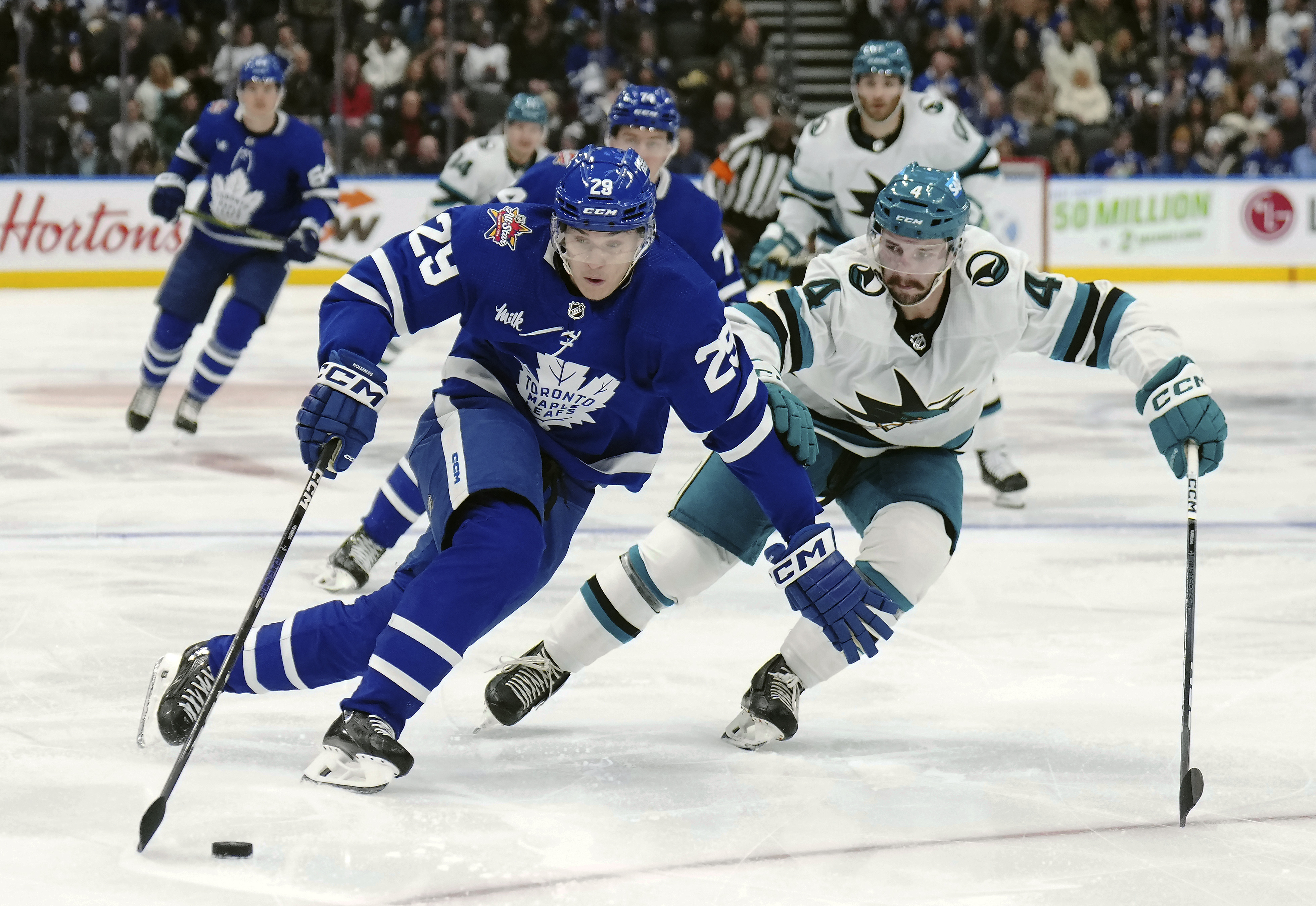 Toronto Maple Leafs forward Pontus Holmberg (29) protects the puck from San Jose Sharks defenseman Kyle Burroughs (4) during the second period of an NHL hockey game, Tuesday, Jan. 9, 2024 in Toronto. 