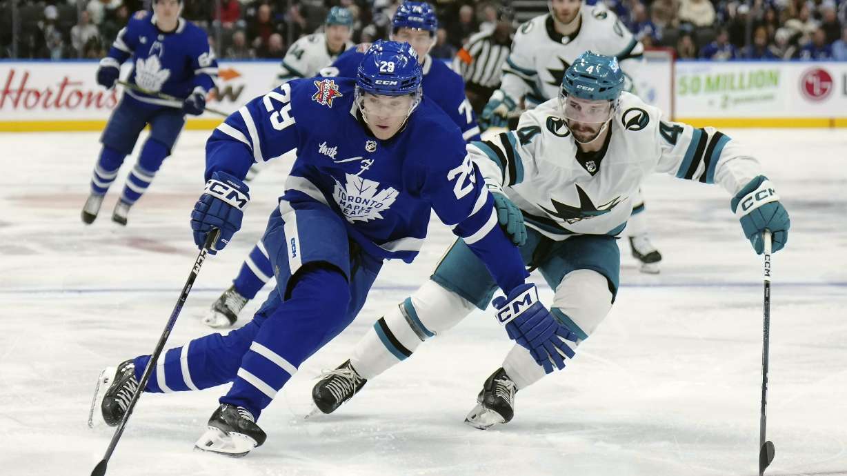 Toronto Maple Leafs forward Pontus Holmberg (29) protects the puck from San Jose Sharks defenseman Kyle Burroughs (4) during the second period of an NHL hockey game, Tuesday, Jan. 9, 2024 in Toronto.