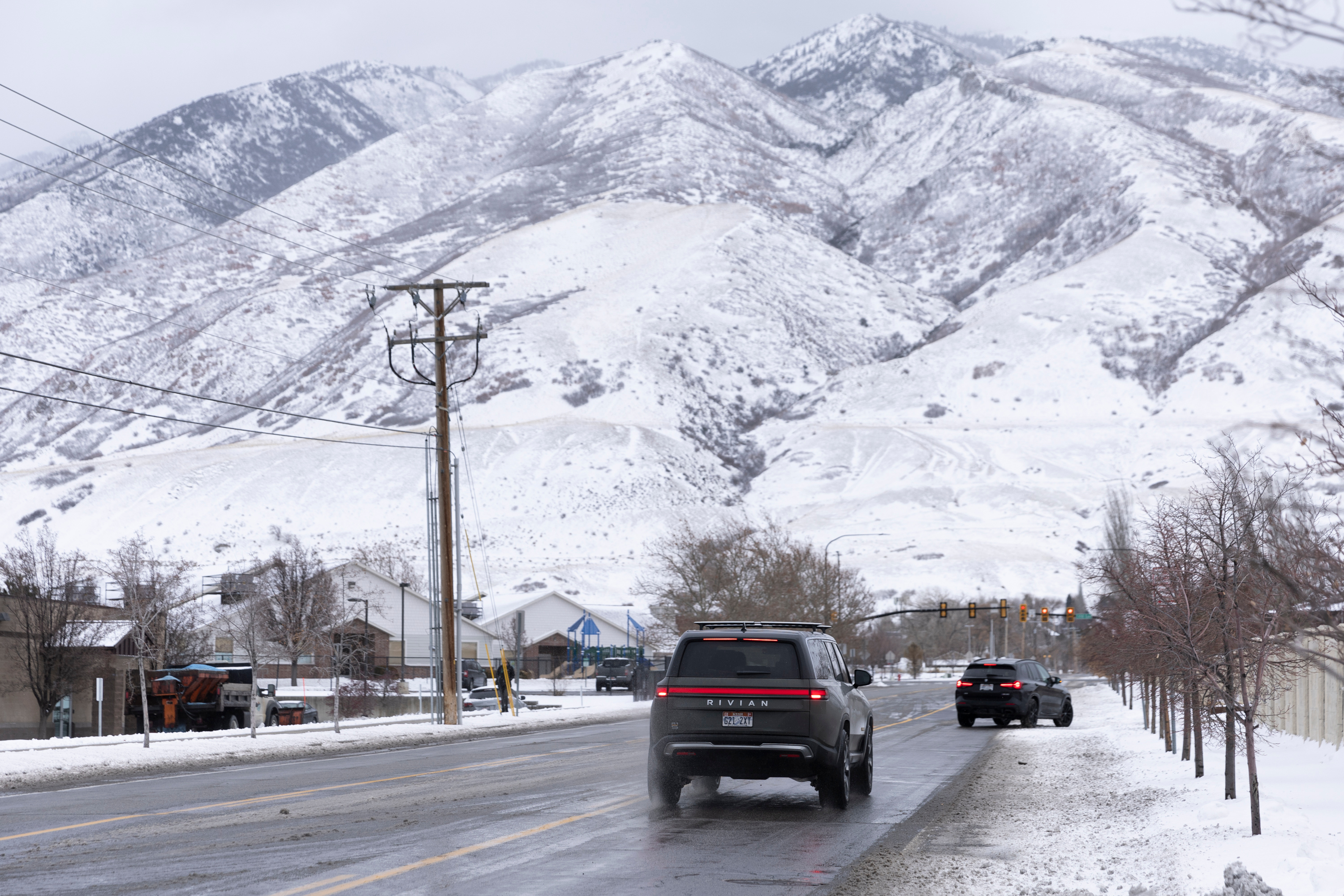Cars are pictured driving after an overnight storm in Draper on Wednesday. Wintry weather and snow squalls are continuing to impact Utah as car crashes total in the hundreds since the onset of snow Friday. 