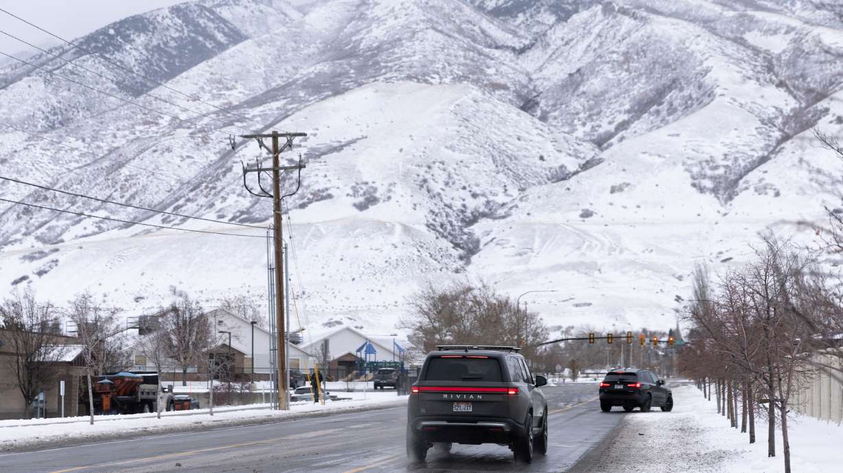 Cars are pictured driving after an overnight storm in Draper on Wednesday. Wintry weather and snow squalls are continuing to impact Utah as car crashes total in the hundreds since the onset of snow Friday.