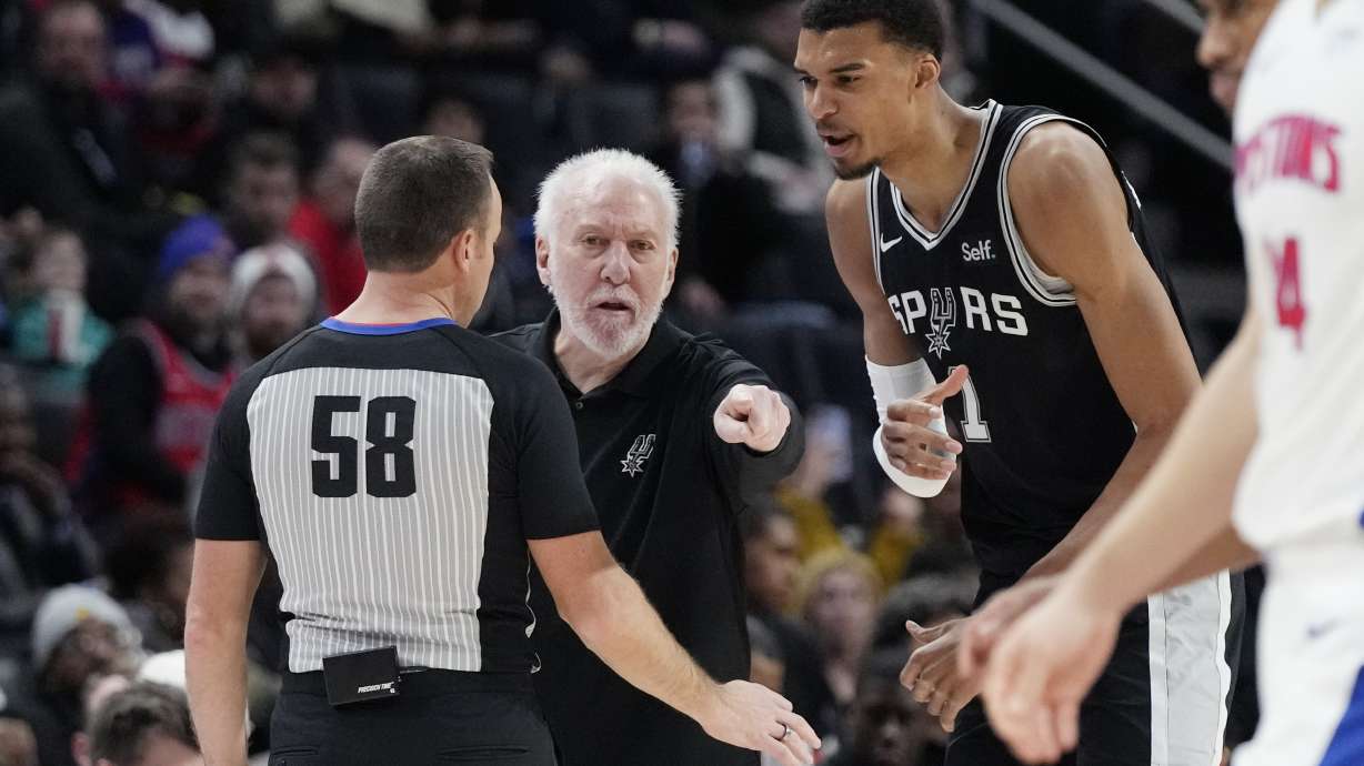 San Antonio Spurs head coach Gregg Popovich and center Victor Wembanyama (1) dispute a call with referee Josh Tiven (58) during the first half of an NBA basketball game against the Detroit Pistons, Wednesday, Jan. 10, 2024, in Detroit.