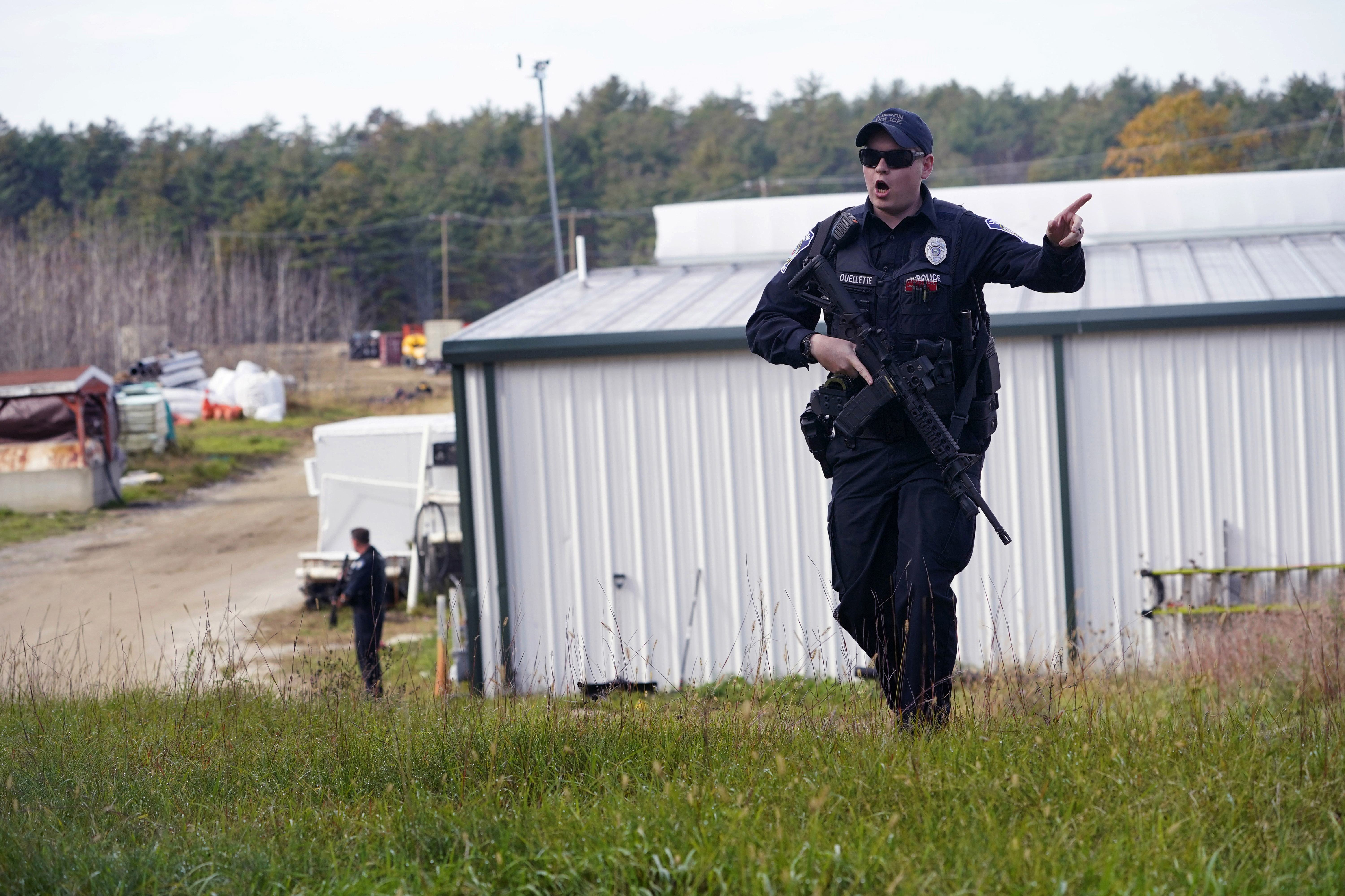 A police officer gives an order to the public during a manhunt for Robert Card at a farm following two mass shootings, Oct. 27, 2023, in Lisbon, Maine. A friend of Card had warned authorities that he was concerned Card was in a dangerous state of mind.