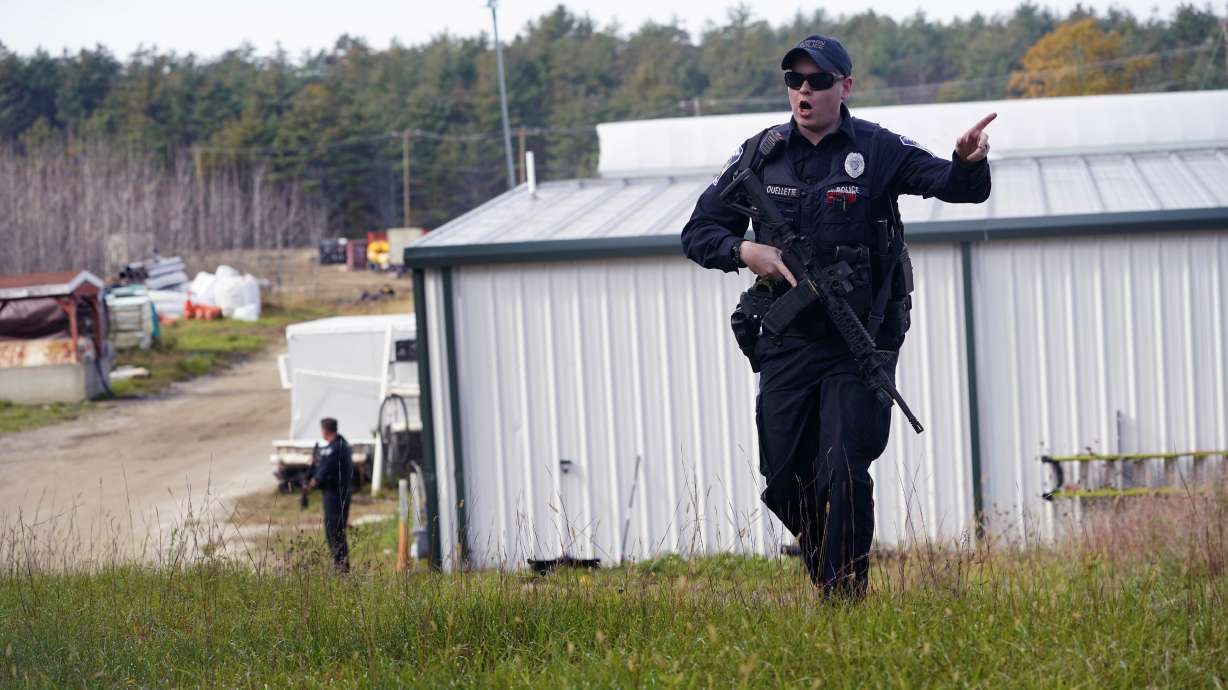 A police officer gives an order to the public during a manhunt for Robert Card at a farm following two mass shootings, Oct. 27, 2023, in Lisbon, Maine. A friend of Card had warned authorities that he was concerned Card was in a dangerous state of mind.