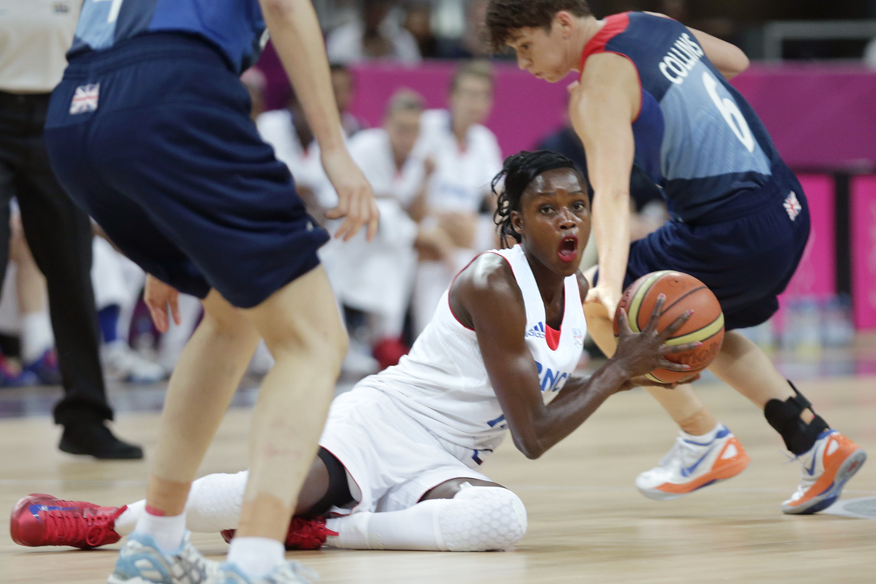 FILE - France's Emilie Gomis looks to pass as she is flanked by Britain's Stef Collins, right, and Natalie Stafford during a women's basketball game at the 2012 Summer Olympics, Friday, Aug. 3, 2012, in London. The former France basketball player serving as an ambassador for the Paris 2024 Olympics has been forced to step down because of a controversy linked to a social media post related to the situation in Gaza.