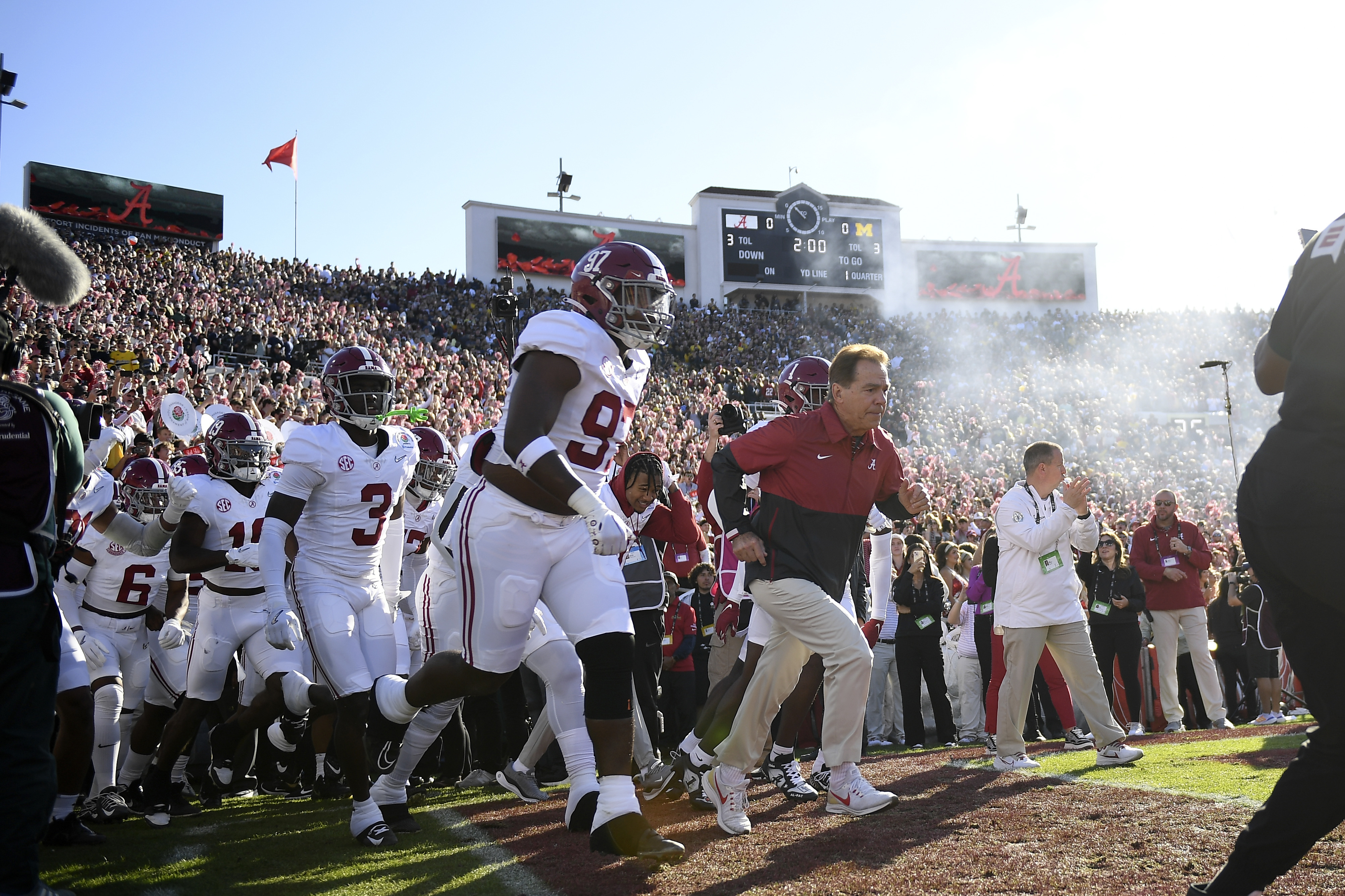 Alabama head coach Nick Saban, right, and his team run onto the field before the Rose Bowl CFP NCAA semifinal college football game against Michigan Monday, Jan. 1, 2024, in Pasadena, Calif. 