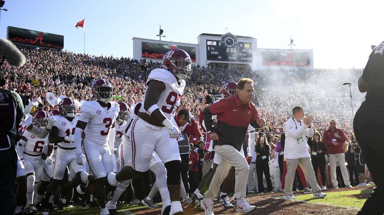 Alabama head coach Nick Saban, right, and his team run onto the field before the Rose Bowl CFP NCAA semifinal college football game against Michigan Monday, Jan. 1, 2024, in Pasadena, Calif.