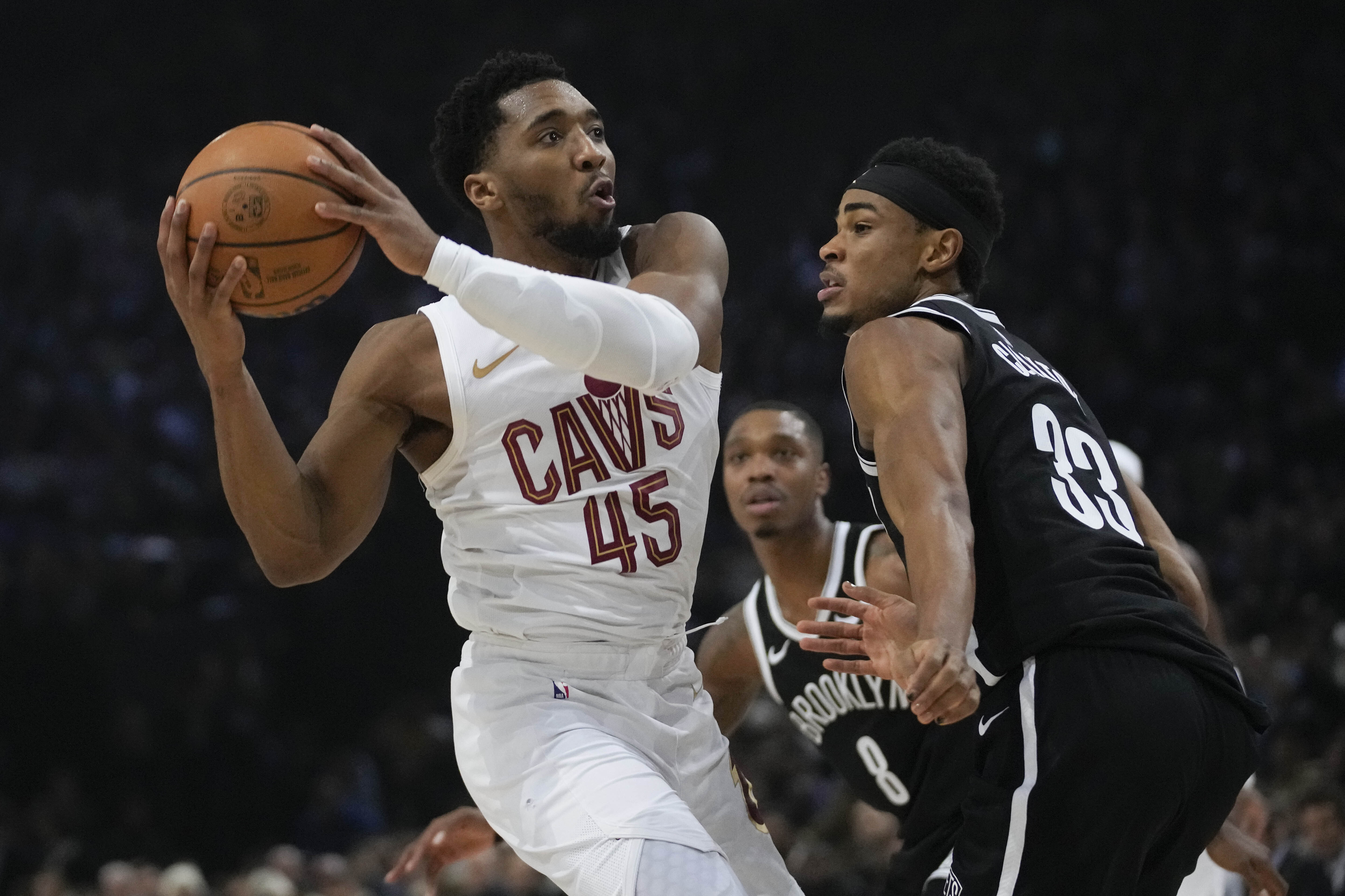 Cleveland Cavaliers' Donovan Mitchell, left, drives to the basket during the NBA basketball game between Brooklyn Nets and Cleveland Cavaliers, at the Accor Arena in Paris, Thursday, Jan. 11, 2024. 
