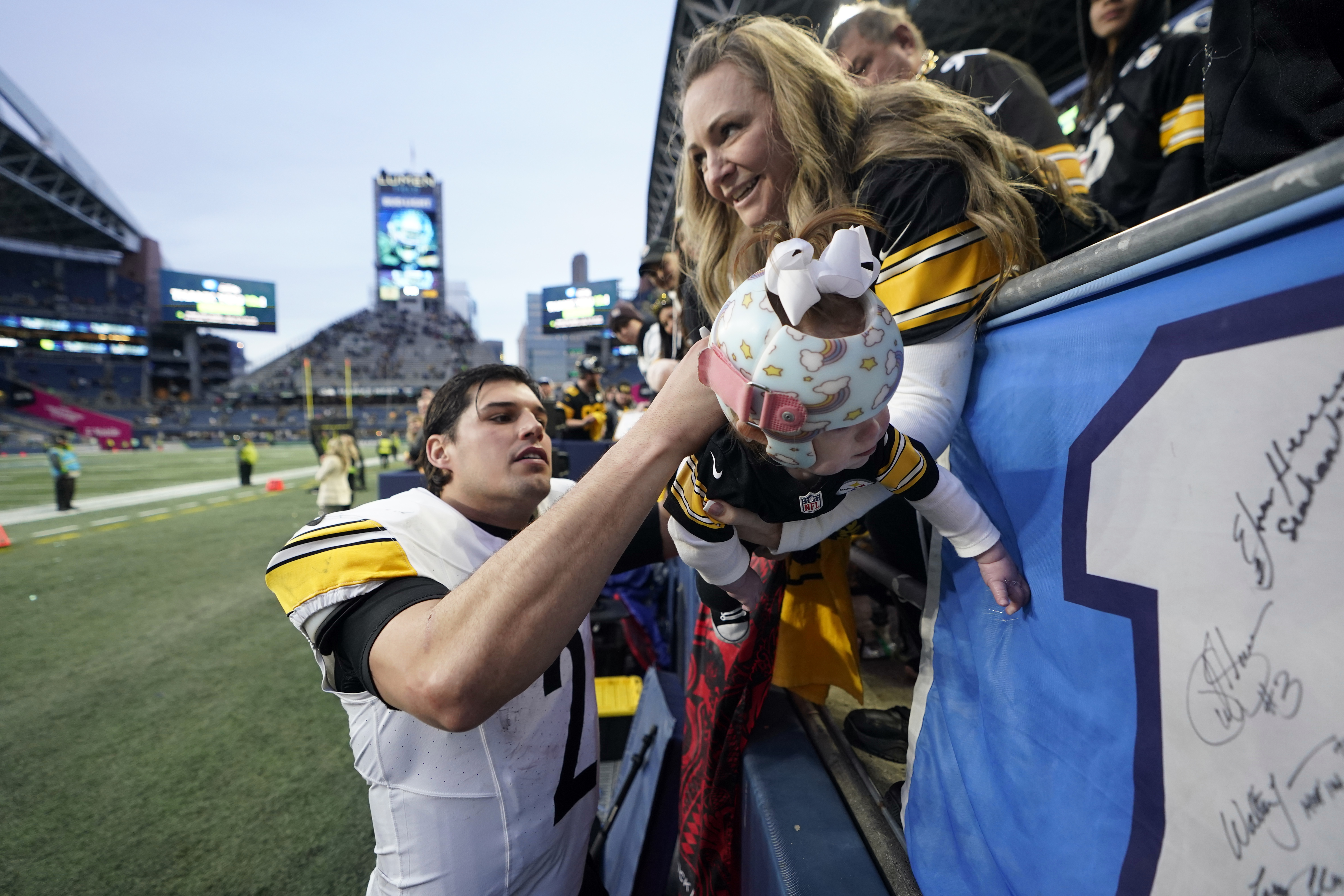 Pittsburgh Steelers quarterback Mason Rudolph autographs a baby's jersey after an NFL football game against the Seattle Seahawks Sunday, Dec. 31, 2023, in Seattle. The Steelers won 30-23. 