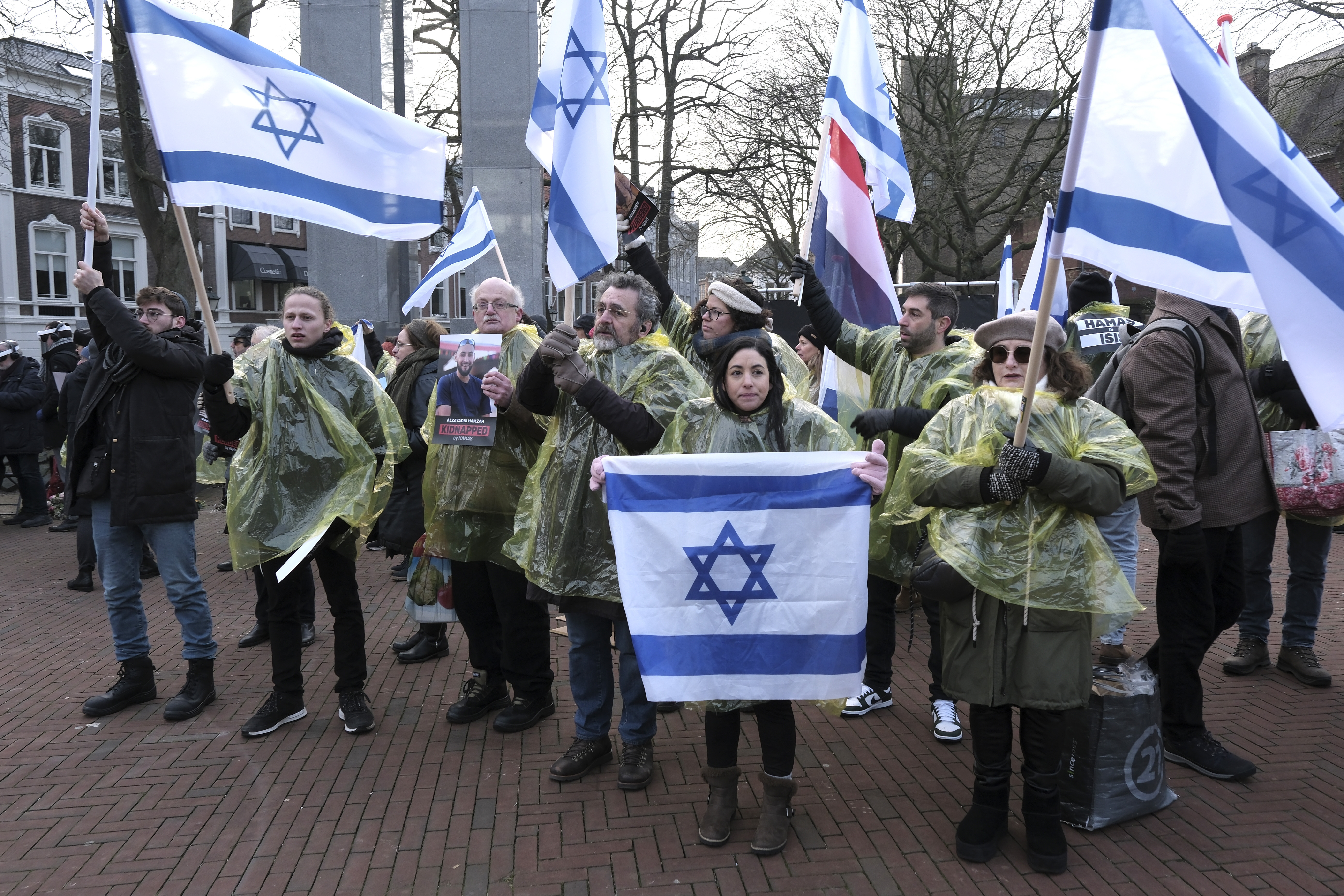Protestors wave Israeli and Dutch flags, and hold photos of the hostages kidnapped during the Oct. 7 Hamas cross-border attack in Israel, during a demonstration outside the International Court of Justice in The Hague, Netherlands, Thursday. The United Nations' top court opened hearings Thursday into South Africa's allegation that Israel's war with Hamas amounts to genocide against Palestinians, a claim that Israel strongly denies.