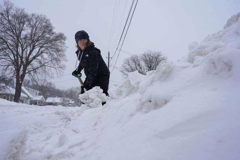 Graphic designer Emily Brewer shovels out her driveway in order to drive to work in Sioux City, Iowa, early on Friday.