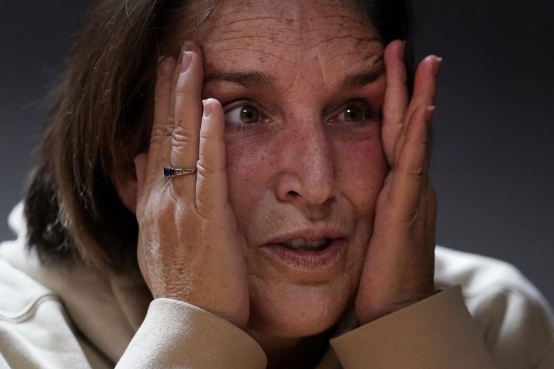 Shooting survivor Tammy Asselin clutches her face while reflecting on surviving a mass shooting by Army reservist Robert Card, during an interview, Dec. 27, 2023, in Lewiston, Maine.