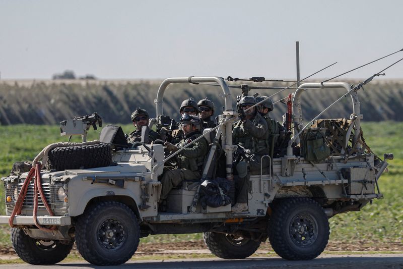 Israeli soldiers ride a military vehicle as they leave Gaza, amid the ongoing conflict between Israel and the Palestinian Islamist group Hamas, as seen from southern Israel, Jan. 13.