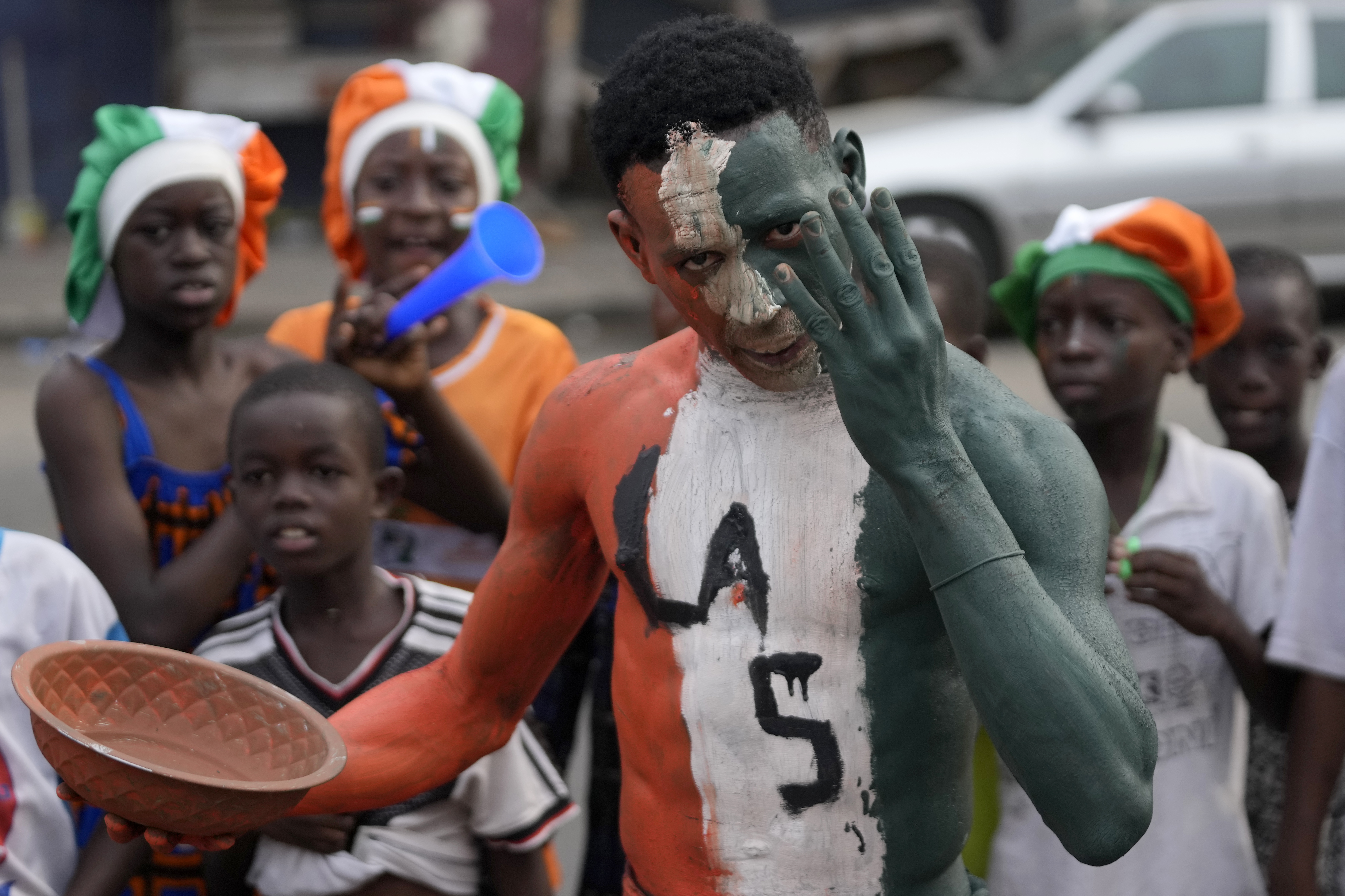 Ivorians sing and dance on the street ahead of the African Cup of Nations Group A soccer match between Ivory Coast and Guinea-Bissau in Abidjan, Ivory Coast, Saturday, Jan. 13, 2024. 